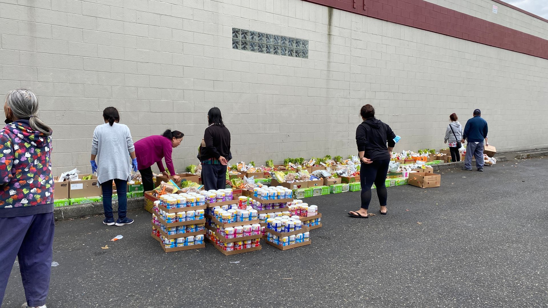 A group of people are standing in front of a large pile of food.