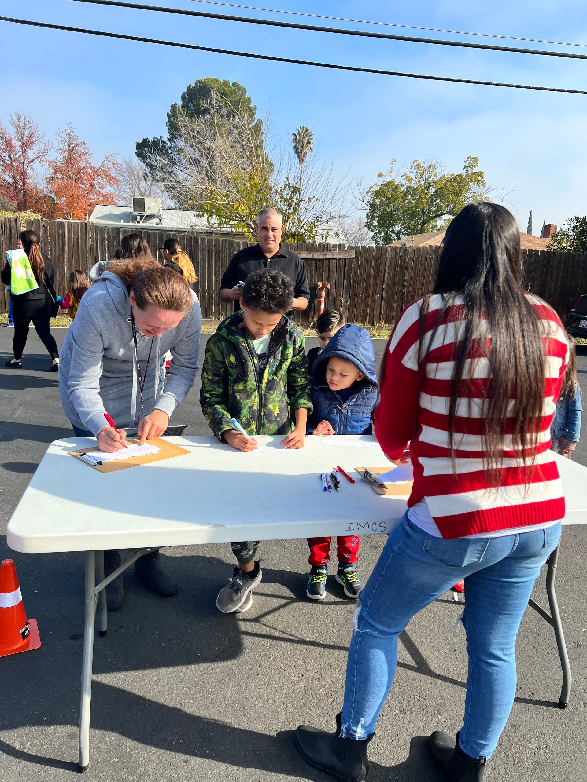 A group of people are standing around a table signing papers.
