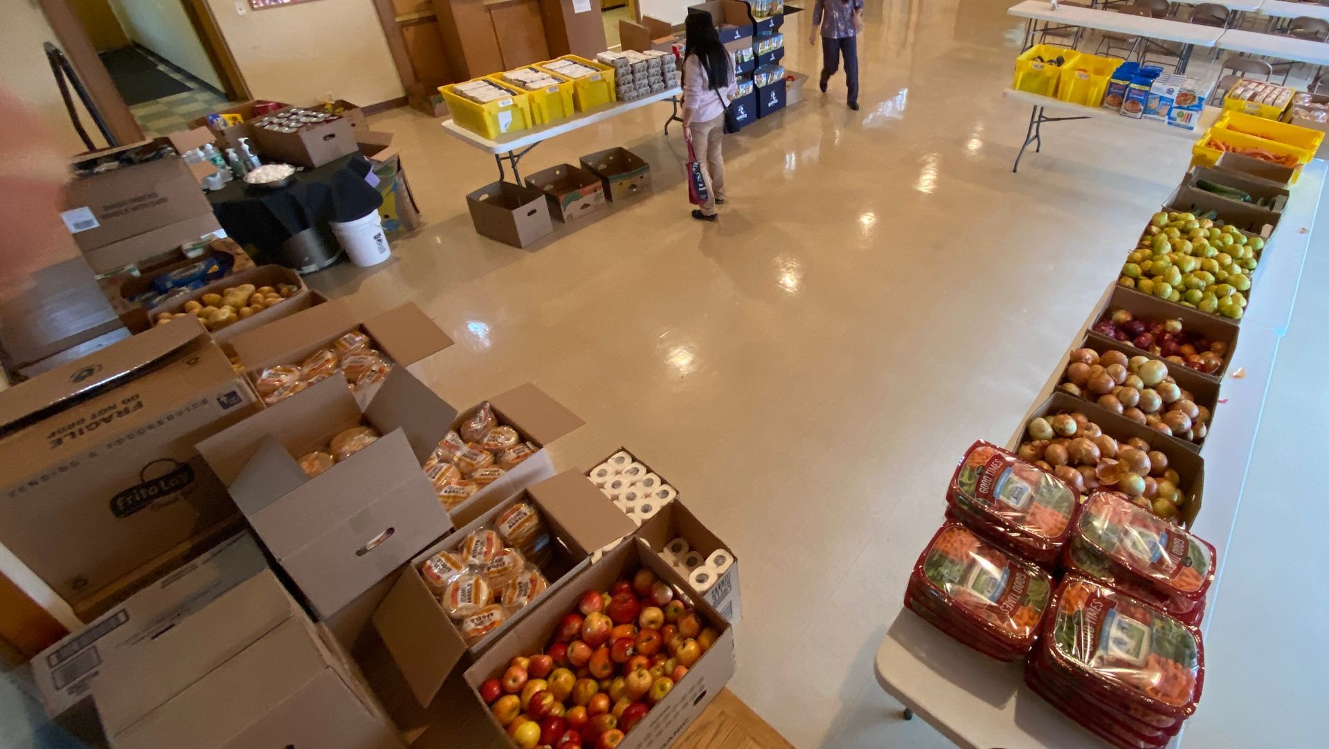 A large room filled with boxes of fruit and vegetables.