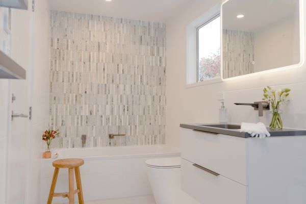 A bathroom with a tub , toilet , sink and mirror.