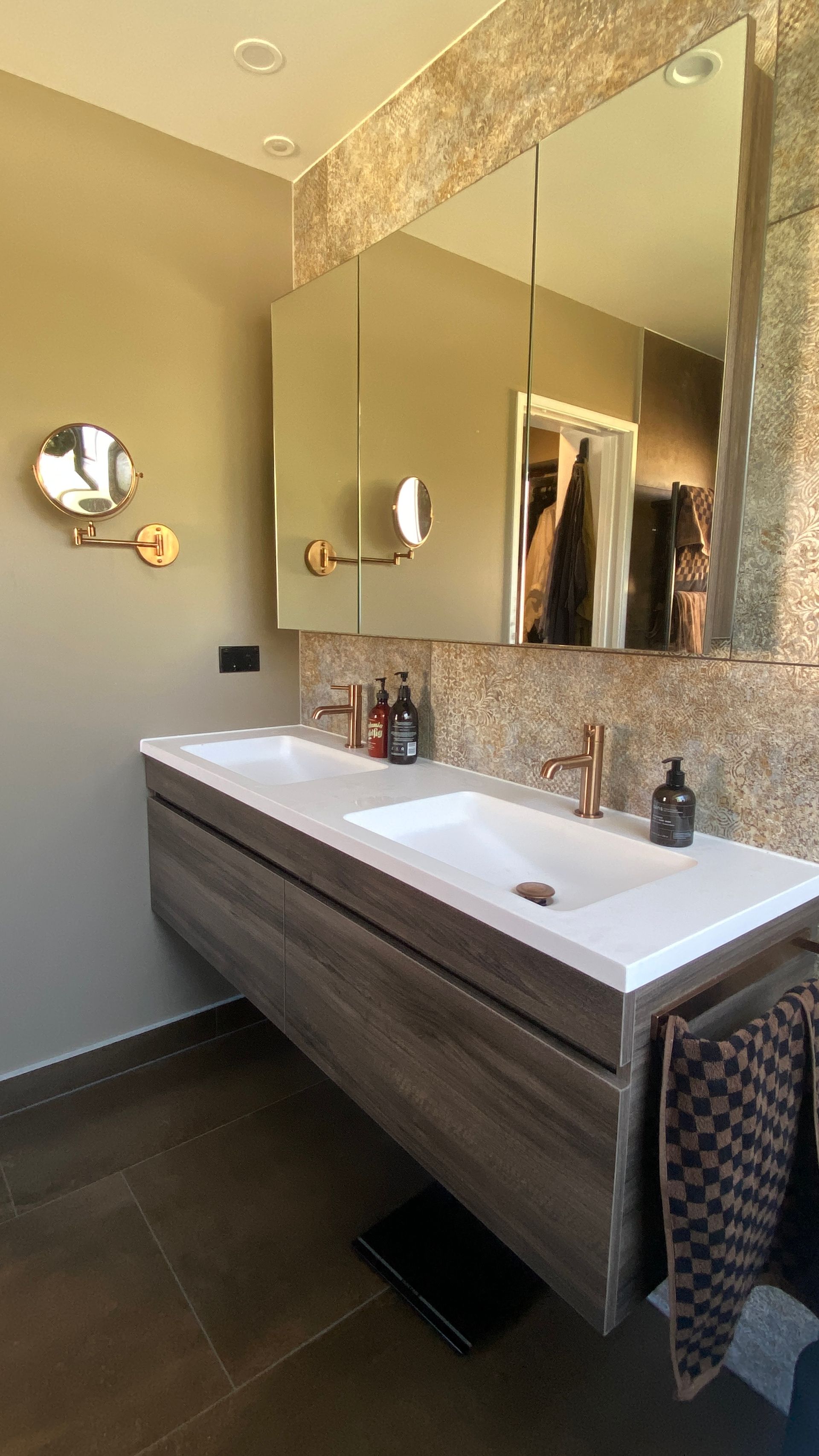 Double sink vanity with wooden drawers in a minimalist small bathroom in Auckland.