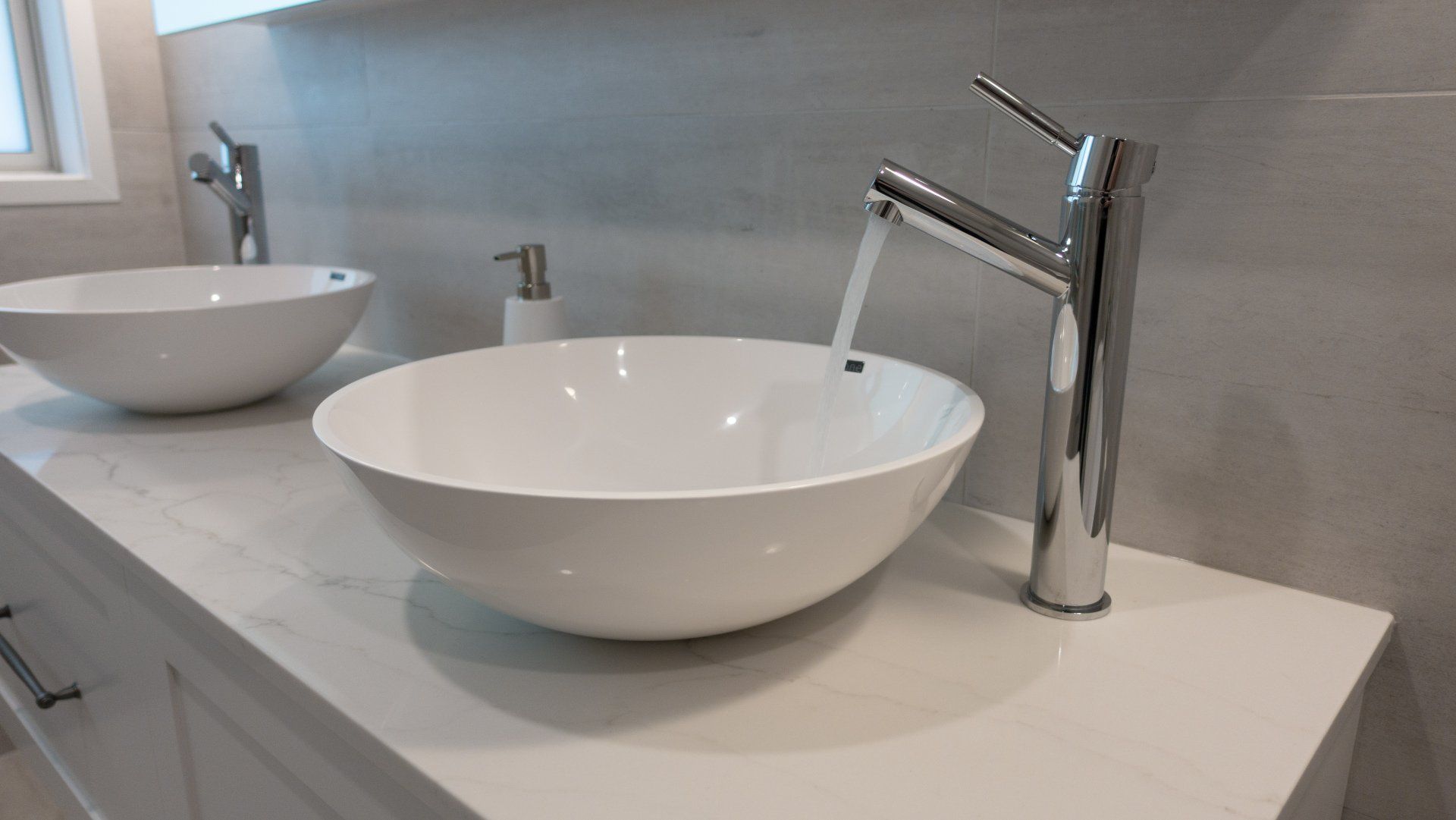 A bathroom with two sinks and a faucet.