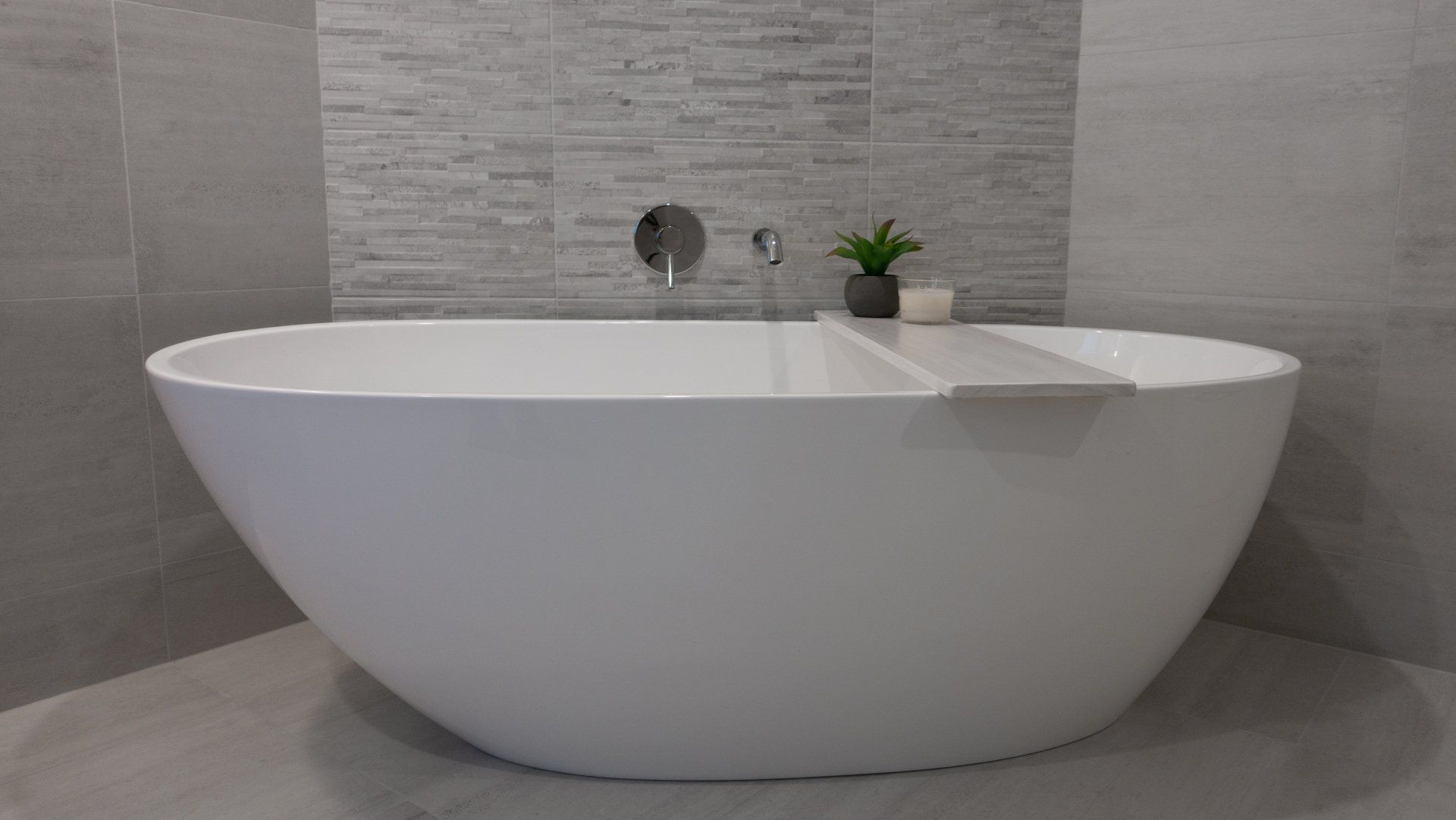 A white bathtub is sitting in a bathroom next to a wall.