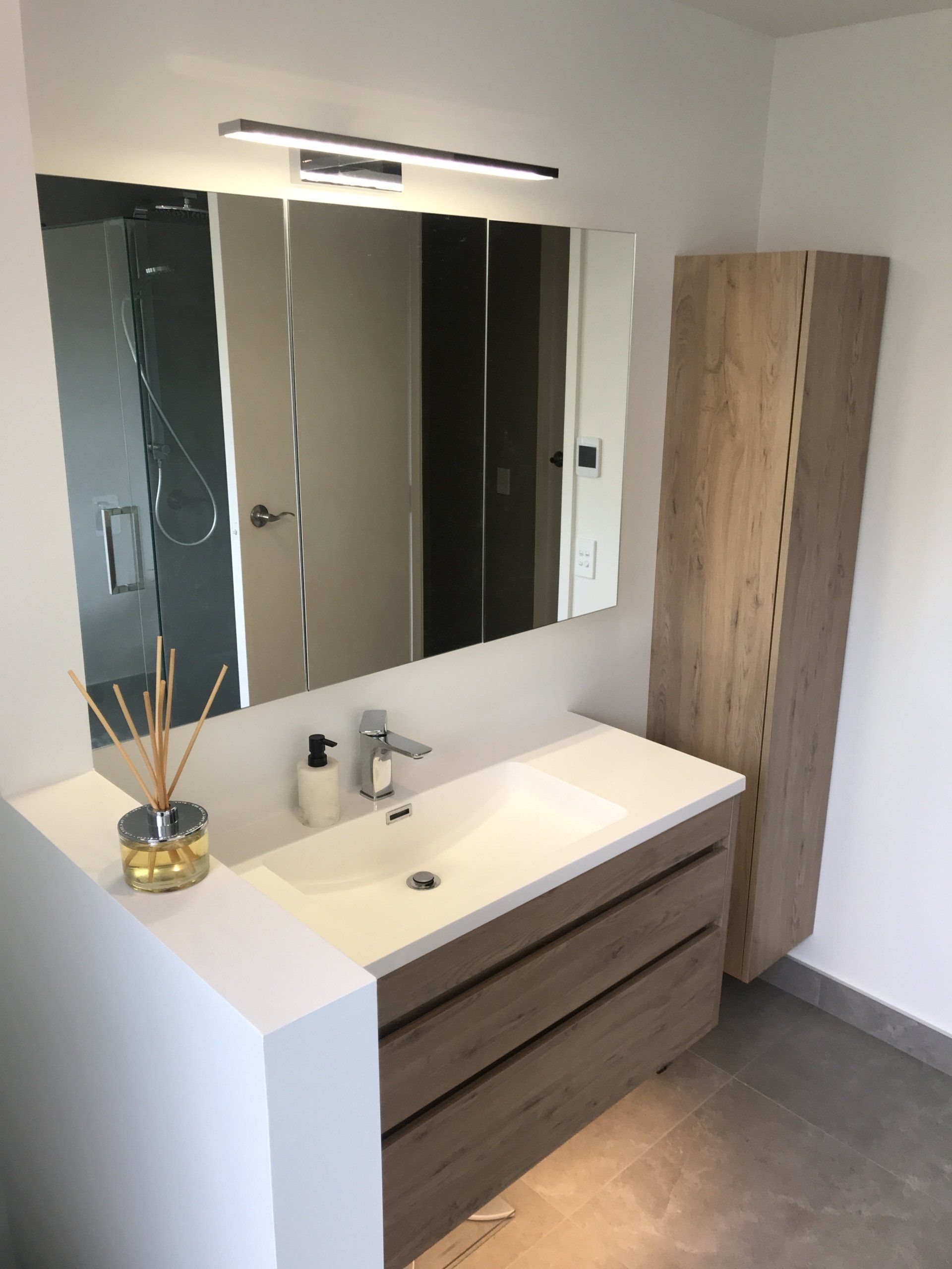 A bathroom with a sink , mirror and cabinets