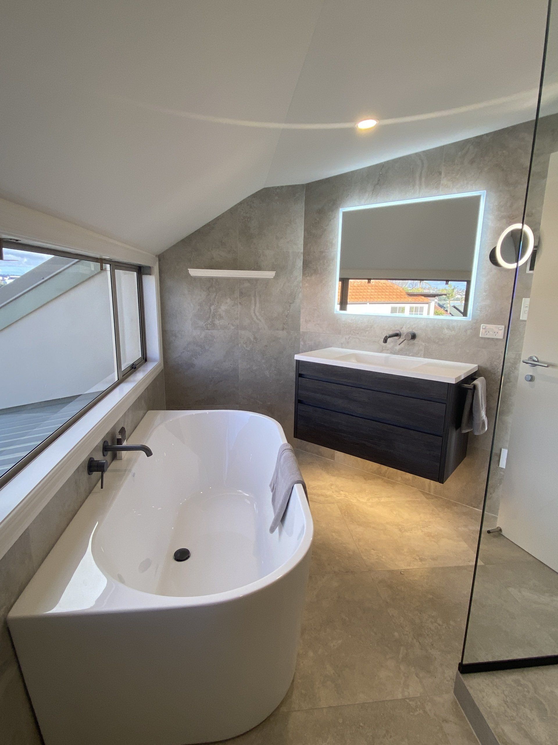 A bathroom with a bathtub , sink and mirror.