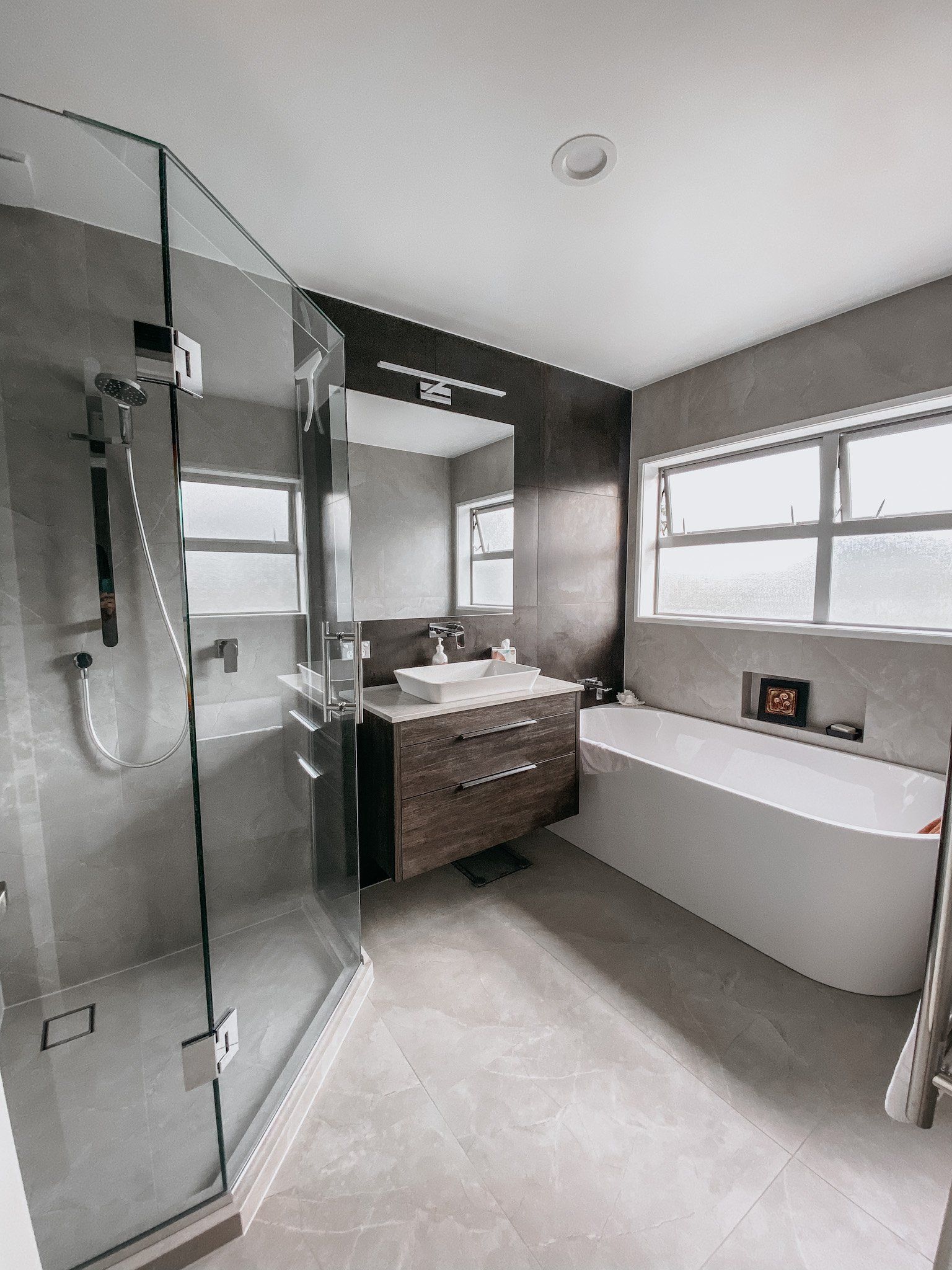A bathroom with a tub , sink , shower and mirror.