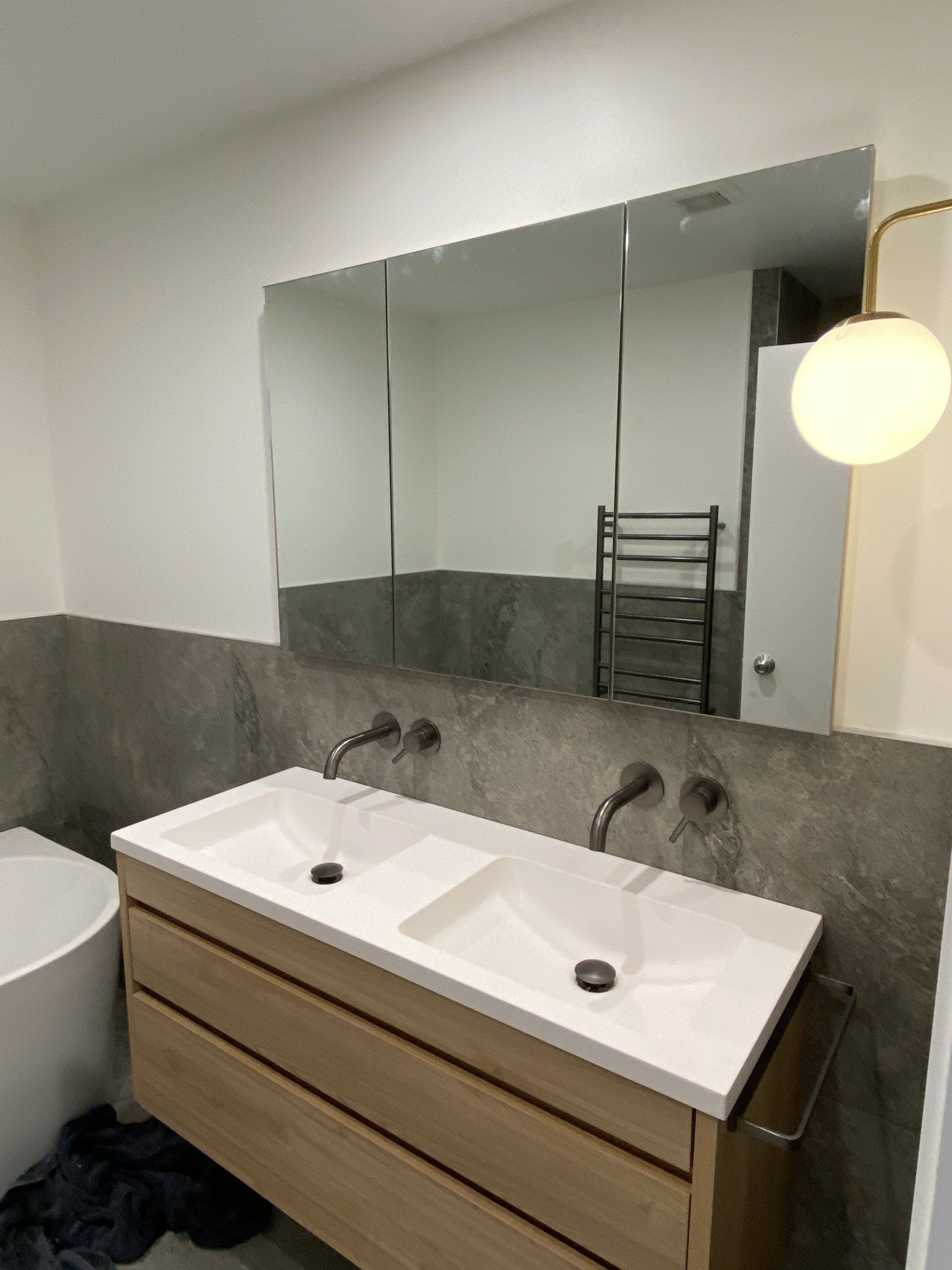 A bathroom with two sinks and a large mirror
