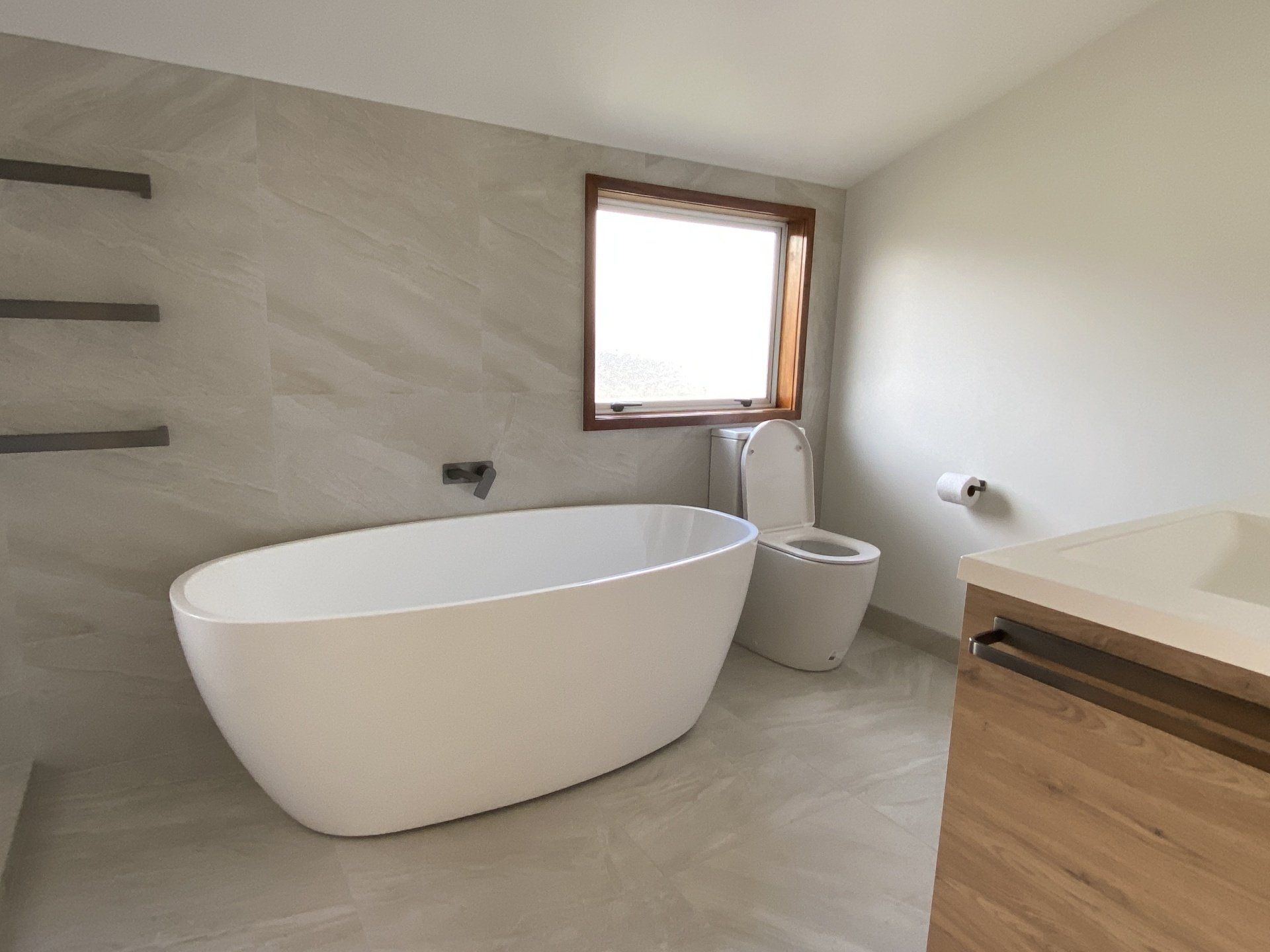 A bathroom with a bathtub , toilet , sink and window.