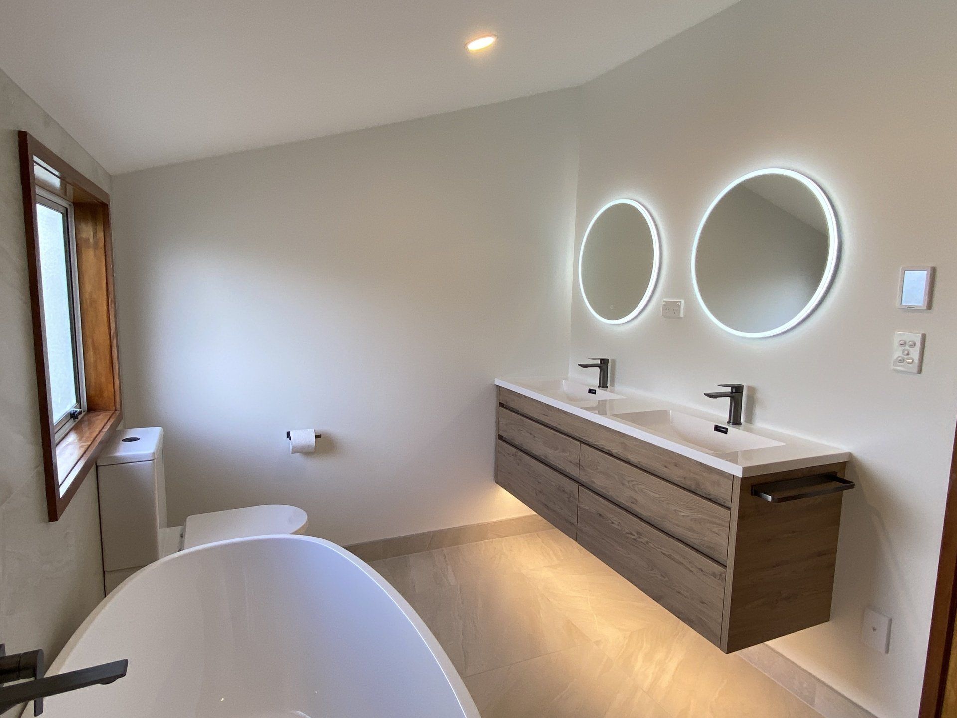 A bathroom with two sinks , a toilet , and a bathtub.