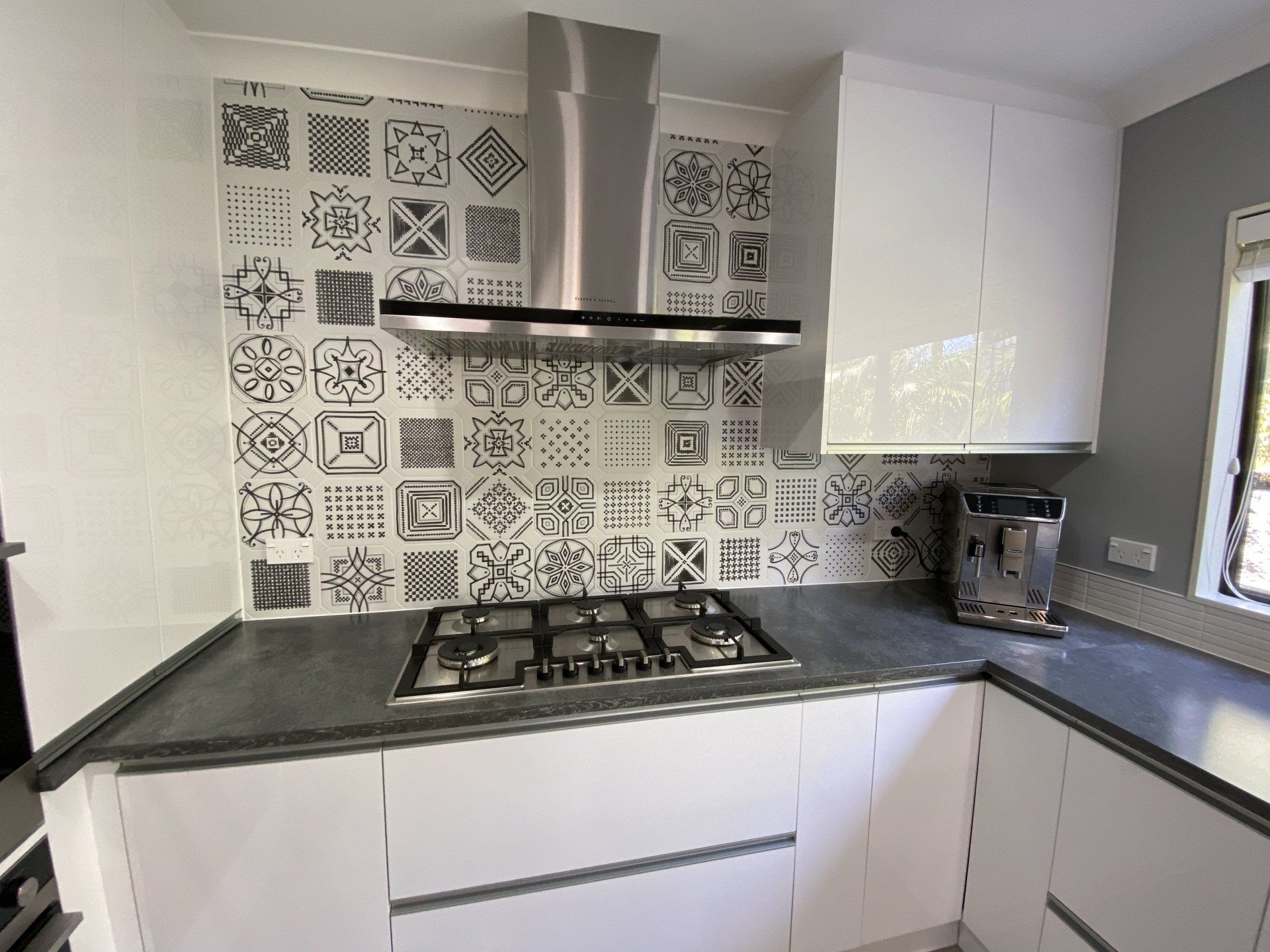 A kitchen with white cabinets and a stove top oven.