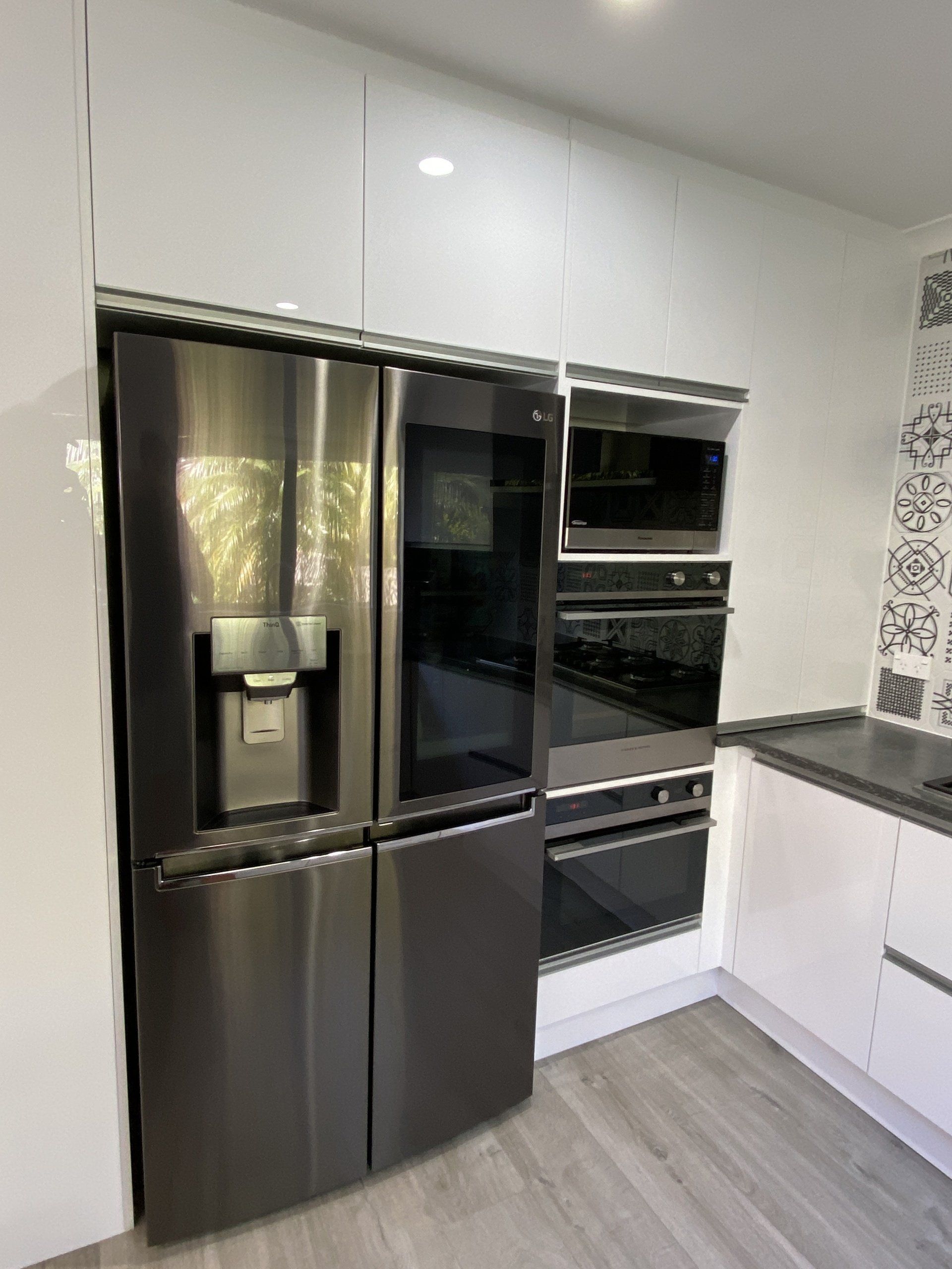 A kitchen with stainless steel appliances and white cabinets.