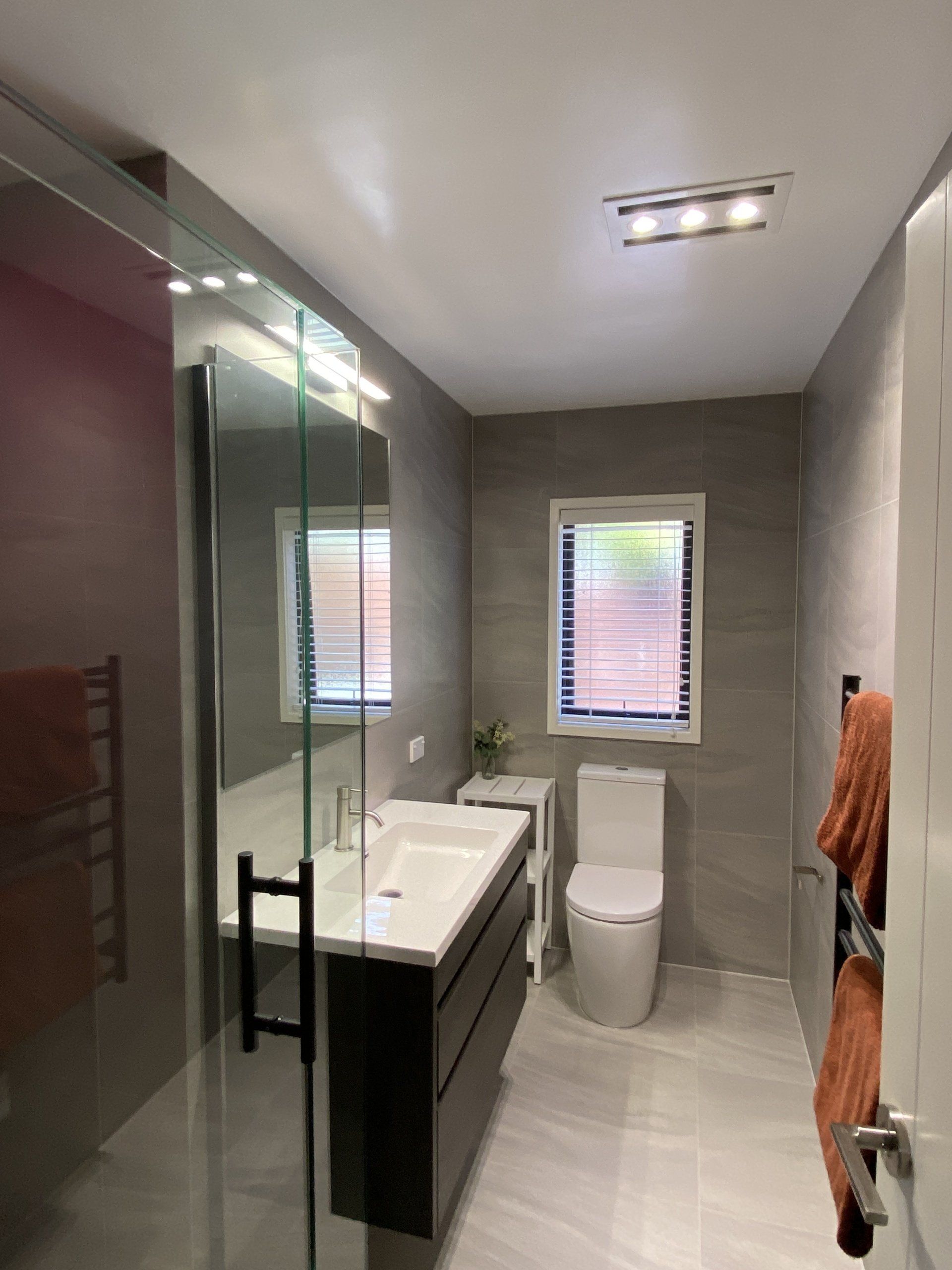 A bathroom with a sink , toilet , and window.