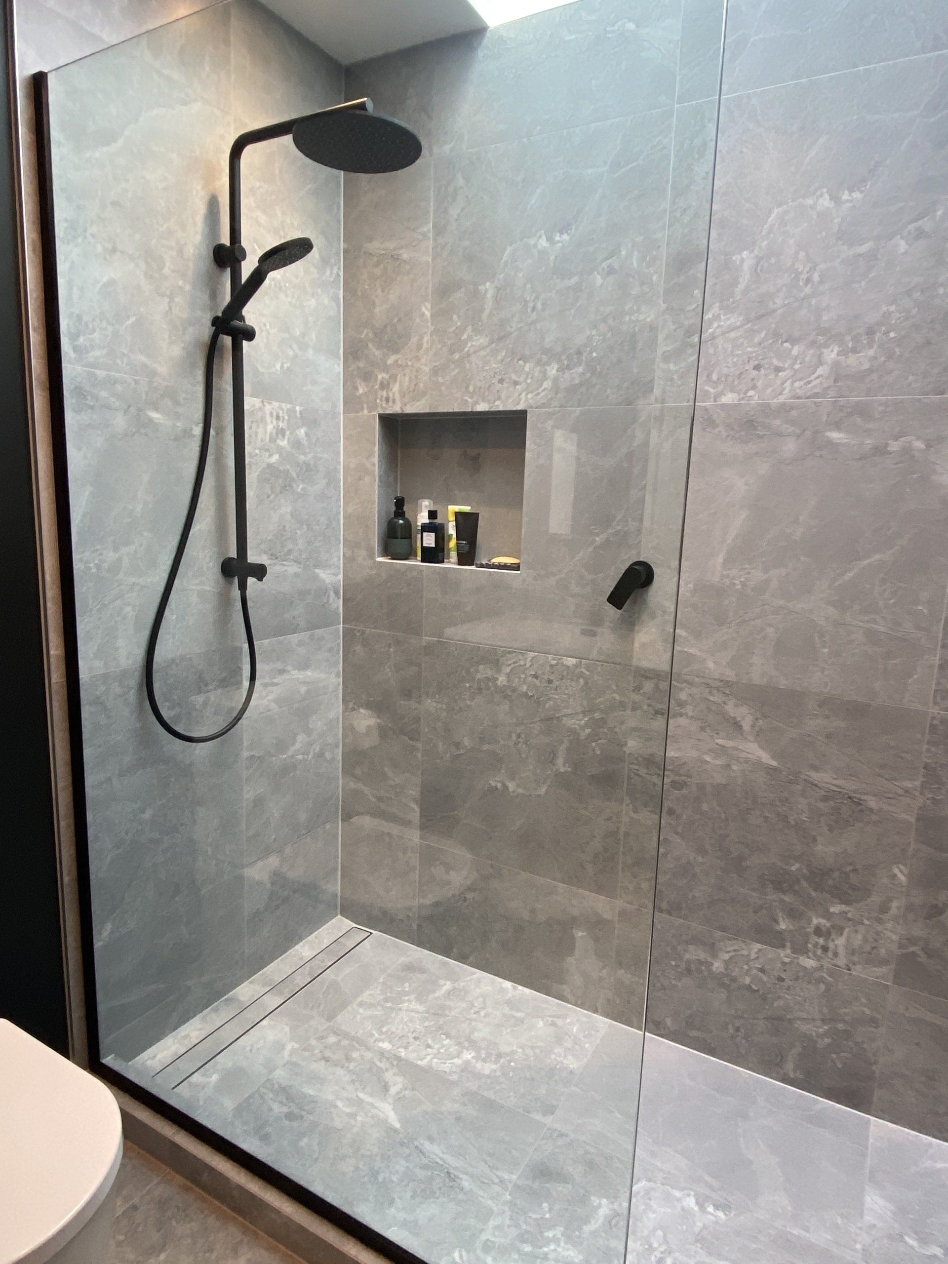 A bathroom with a walk in shower and a toilet.