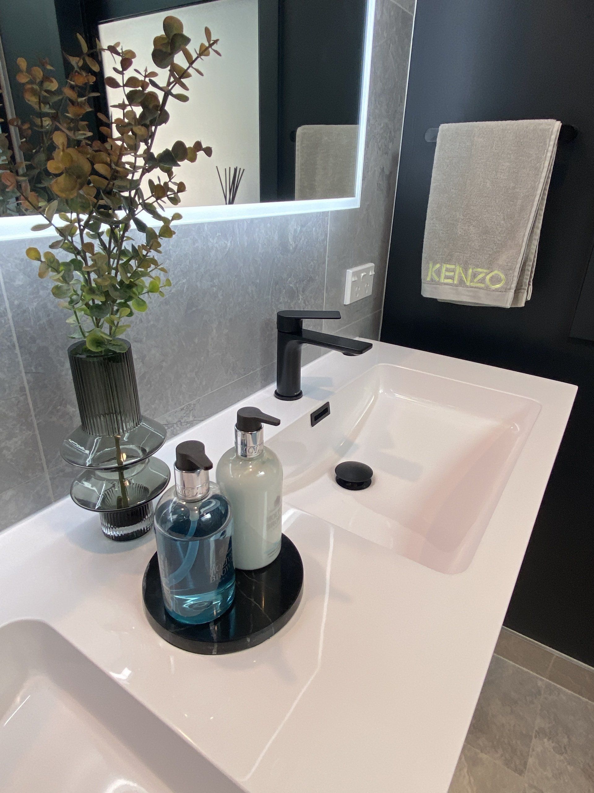 A bathroom sink with two bottles of soap on it.