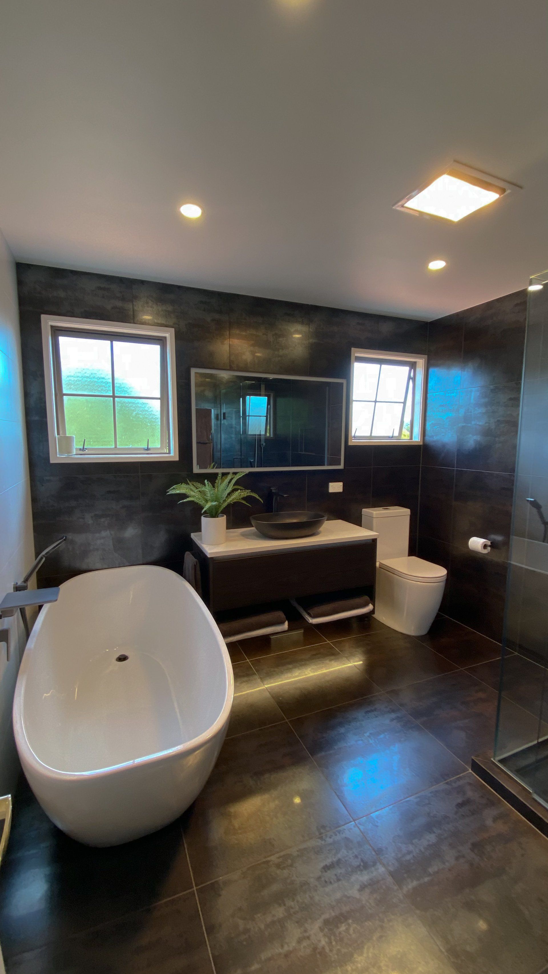 A bathroom with a bathtub , toilet , sink and mirror.
