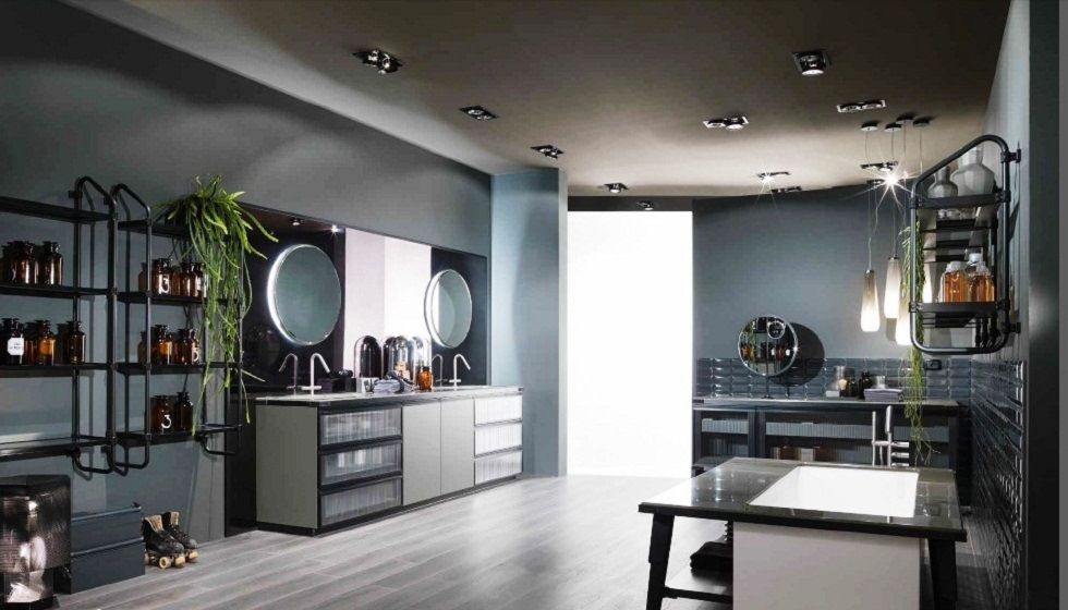 Bagno di colore grigio con postazioni per lo styling, specchi, mensole e un tavolo centrale sotto le luci a soffitto.