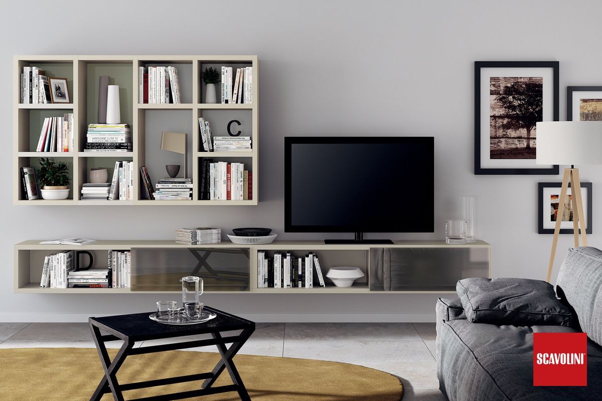 Soggiorno moderno con mensole a muro, televisore, tavolini da caffè e divano grigio su un tappeto.