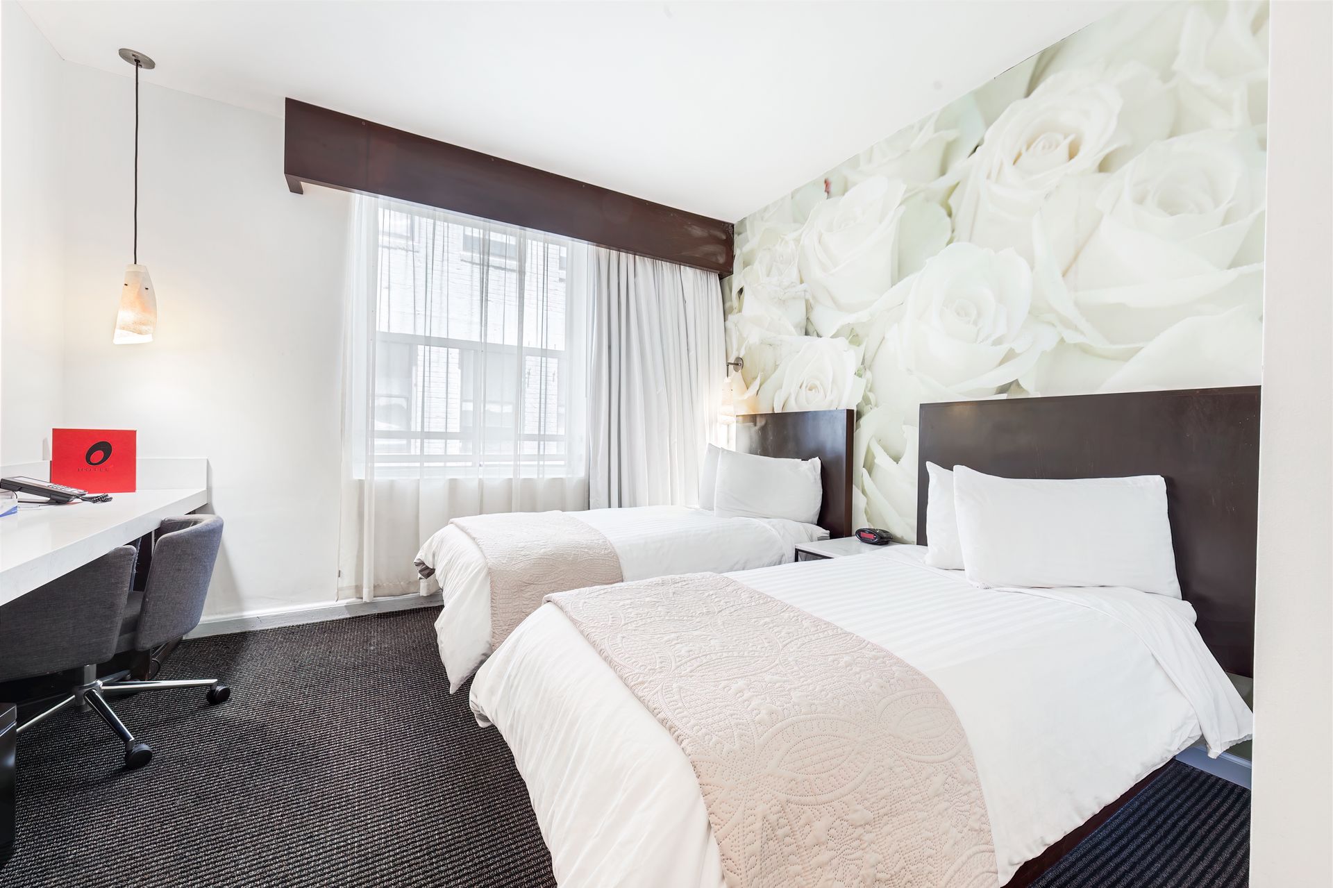 A hotel room with two beds and a desk