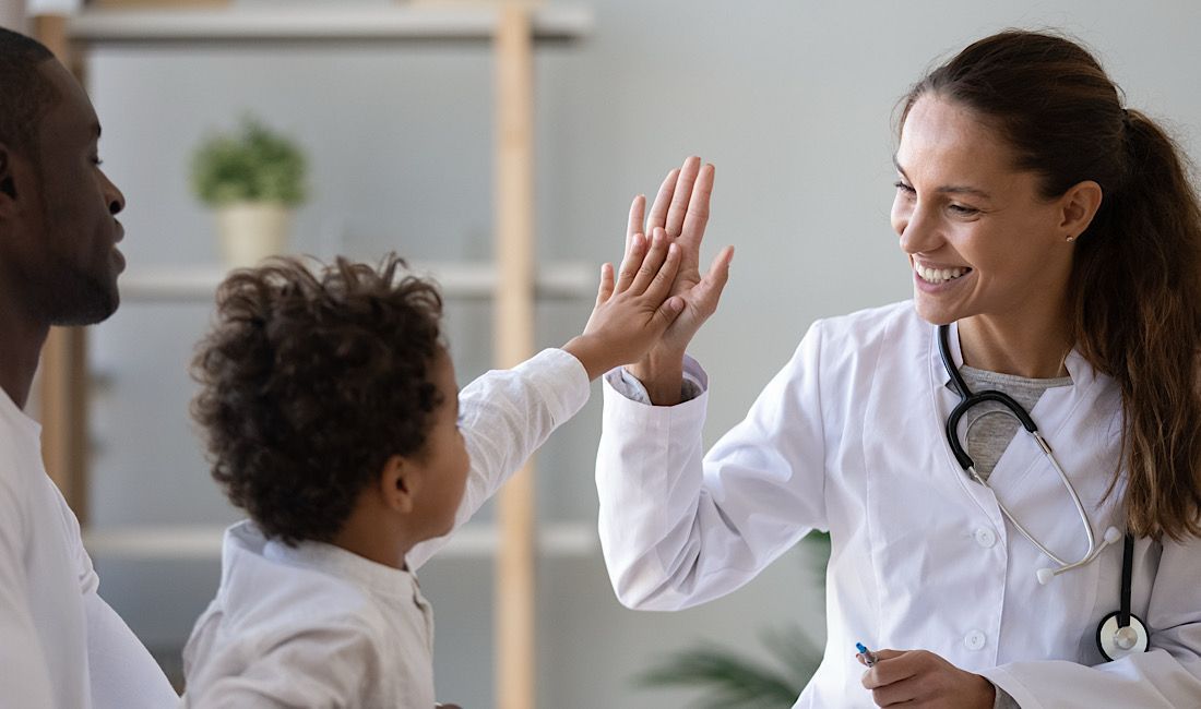 Physician extender high-fiving a child at the doctor's office in Pittsburgh, PA.