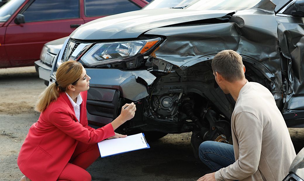 woman evaluating car accident and writing down observations