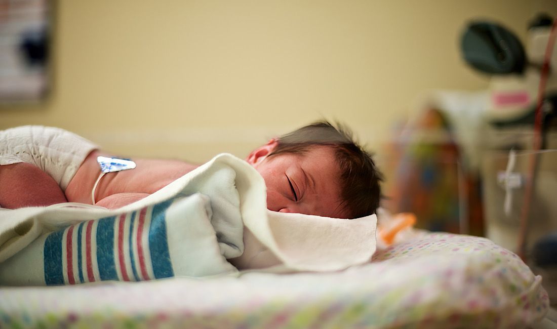 Newborn at the hospital laying in nursery carriage