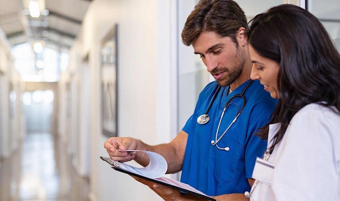 Nurse practitioner and physician reviewing a patient's medical chart for proper diagnosis.