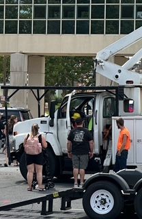 A group of people are standing next to a large white truck.