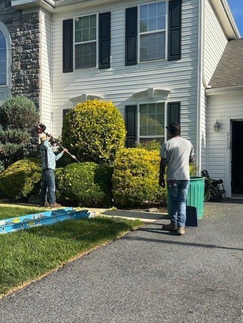 A couple of men are standing in front of a house.