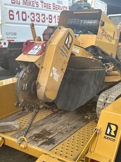 A stump grinder is sitting on top of a trailer.