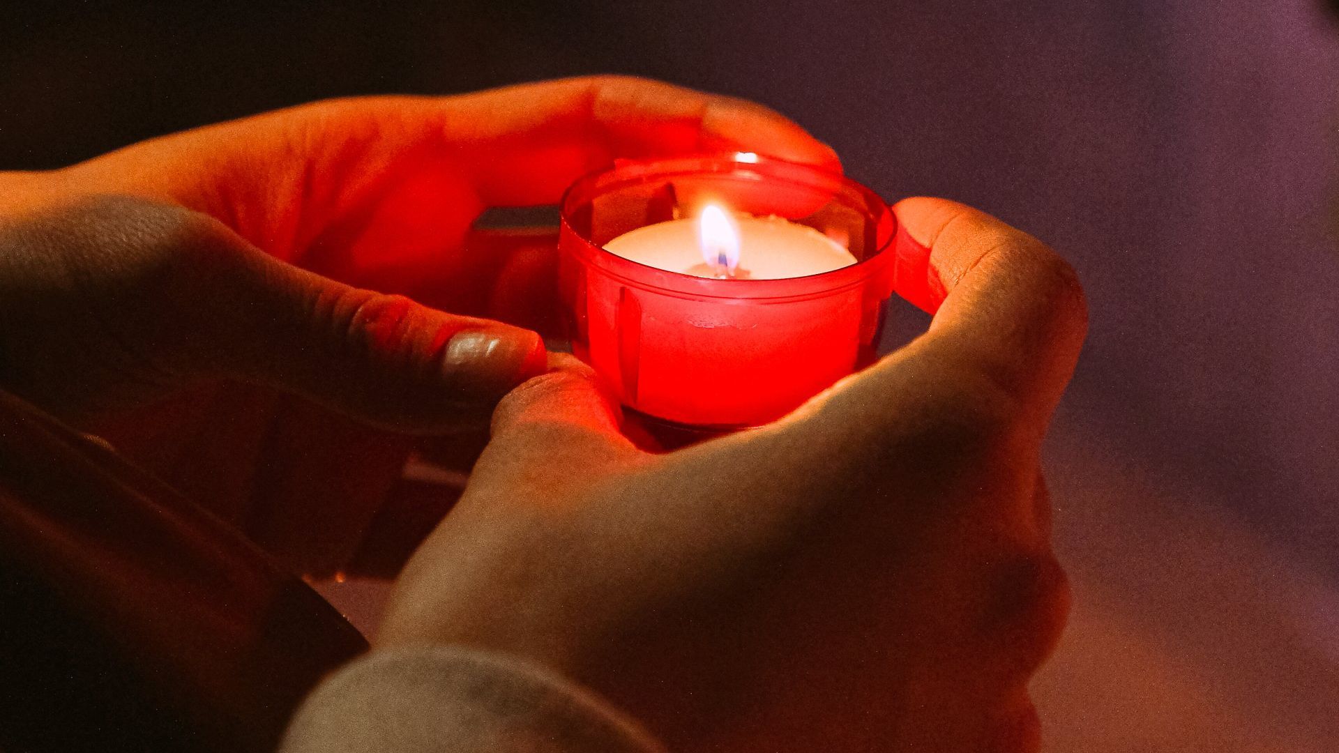 Lit candle in a faith radio network streamed service