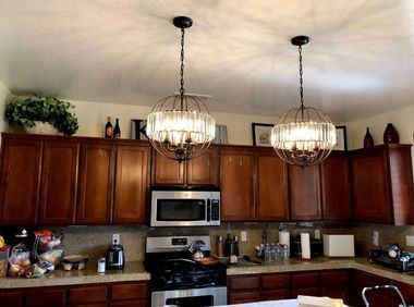 Kitchen with wooden cabinets, stainless steel appliances, and two hanging pendant lights over the counter.