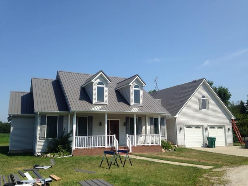 Dark green metal roof with grasses in front yard — Croswell, MI — Parraghi Roofing & Sheet Metal, LLC