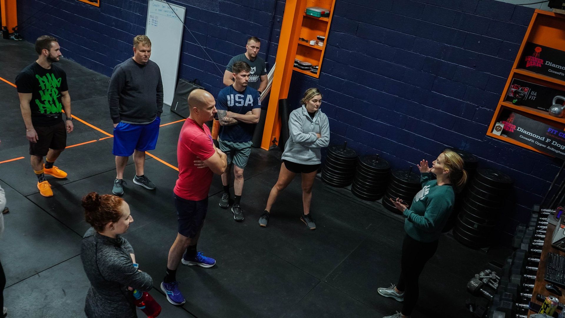 A group of people are standing in a circle in a gym.