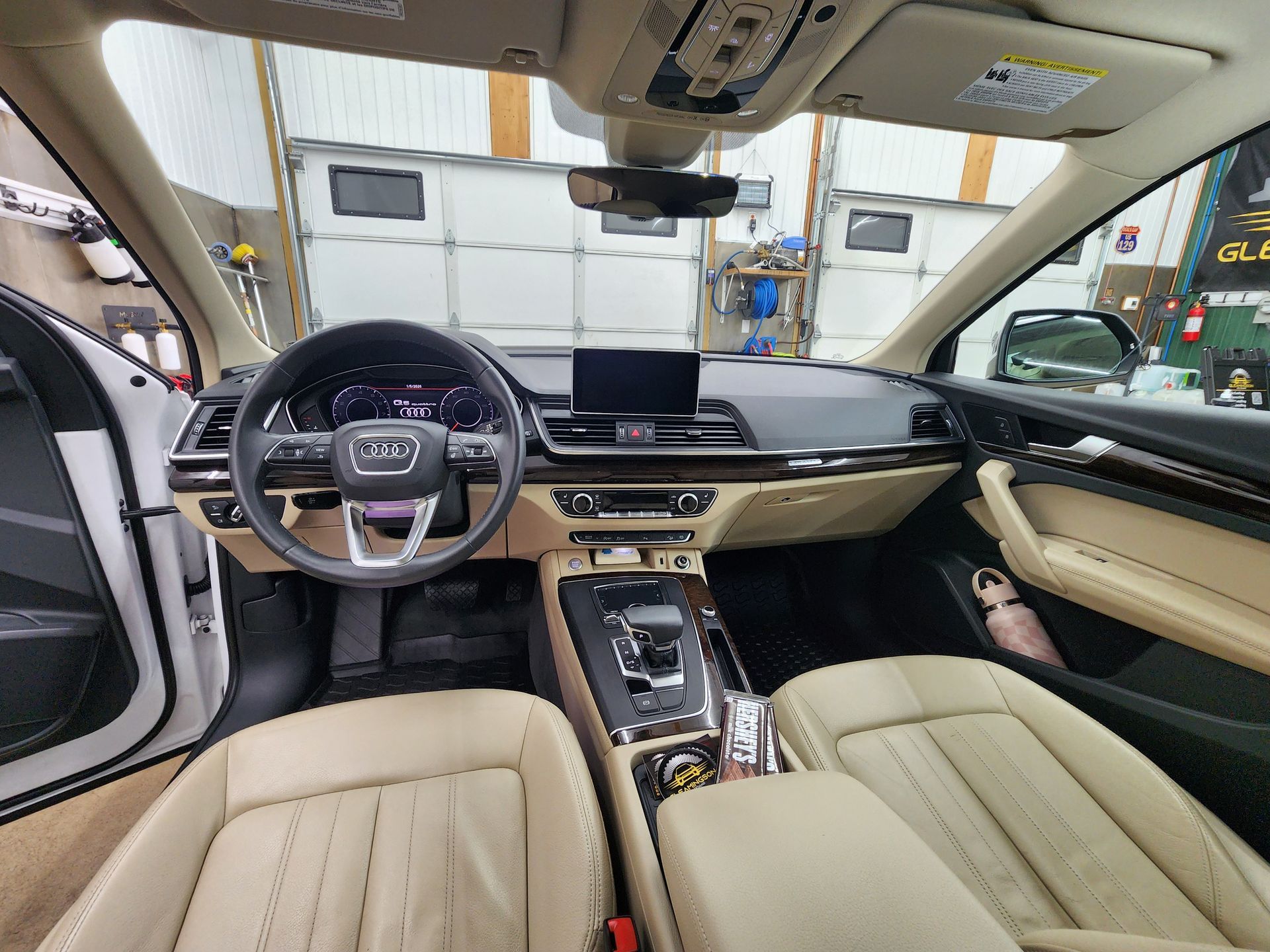Interior view of a beige and black Audi car, showing dashboard, seats, and central console.