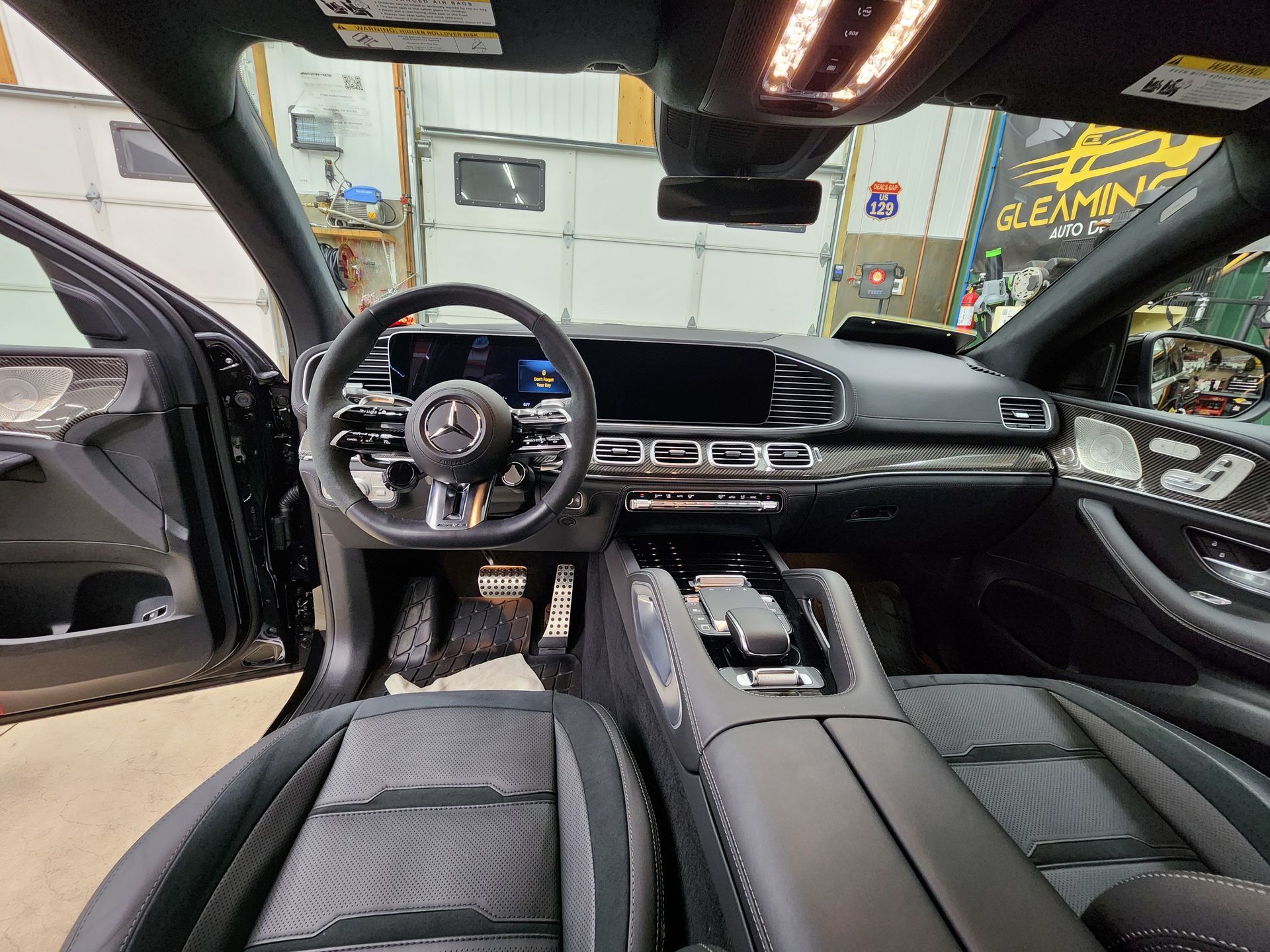 Interior view of a black Mercedes SUV dashboard with steering wheel, seats, and console.