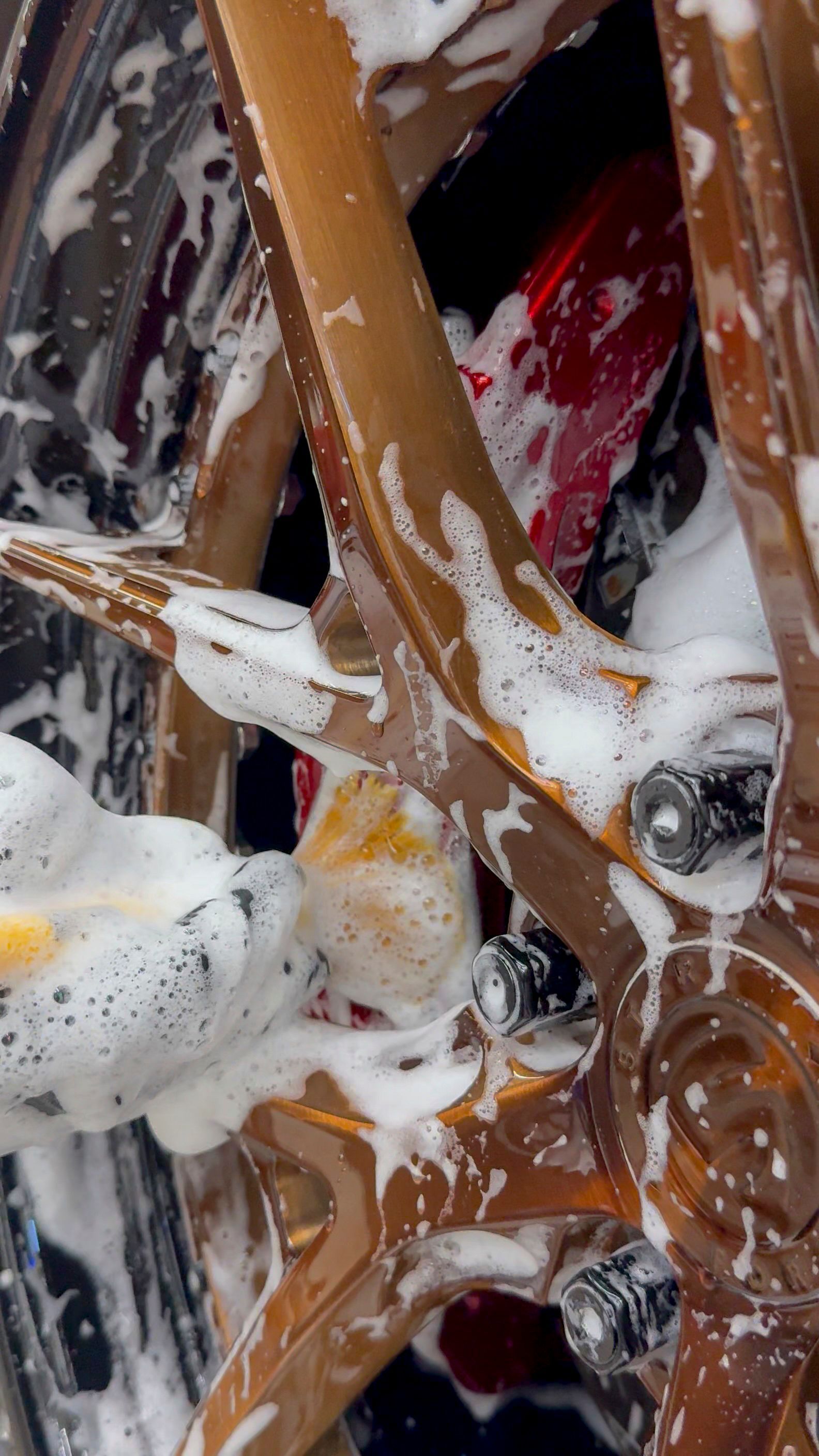 Wheel of a vehicle being washed with soapy water.