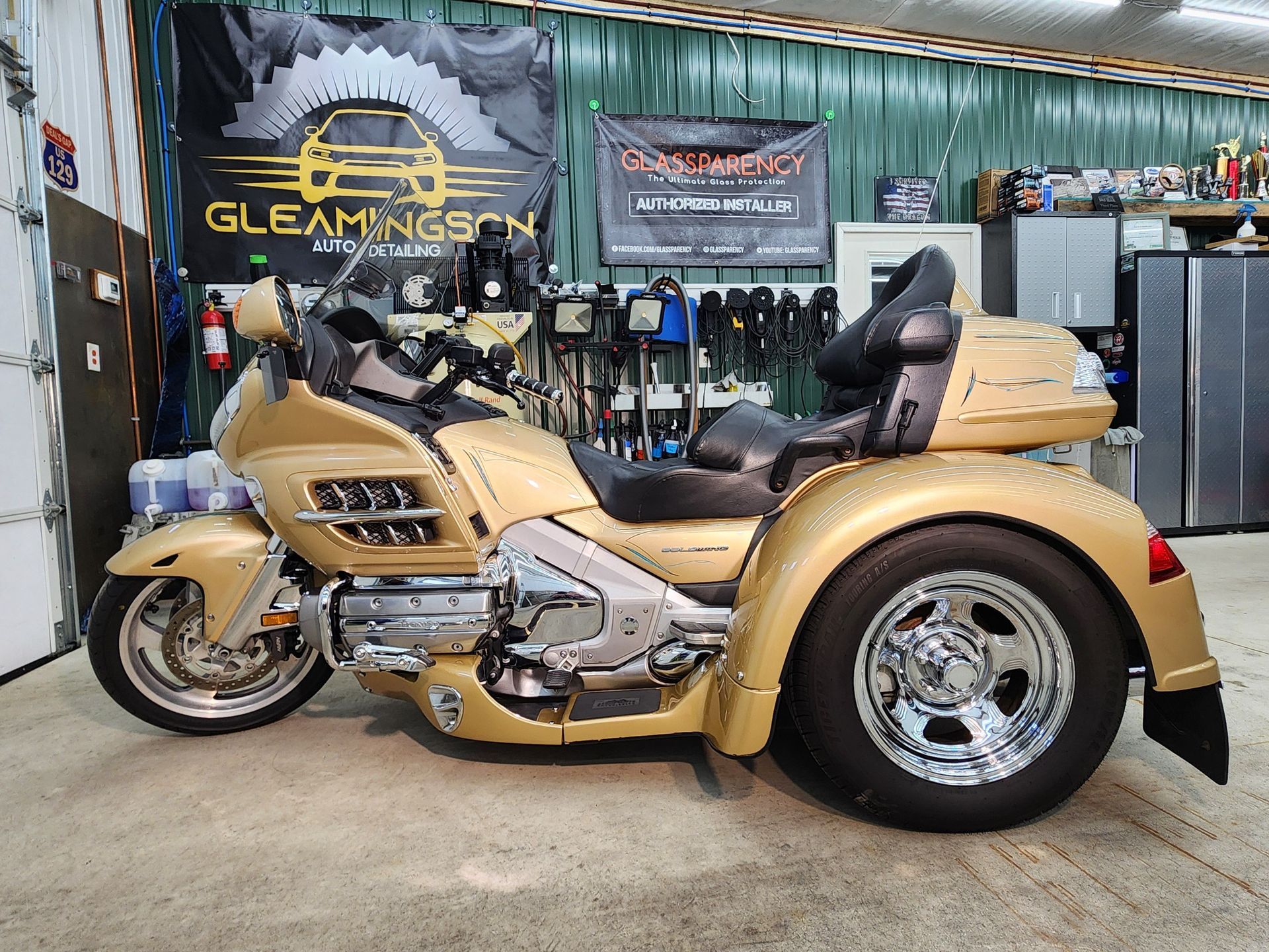 Gold trike motorcycle inside a garage.