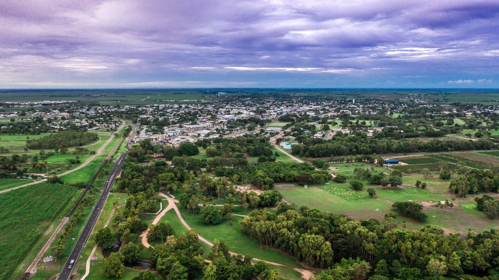 An Aerial View Of A Small Town Surrounded By Trees And Fields — Day & Night Towing & Transport In Ayr, QLD
