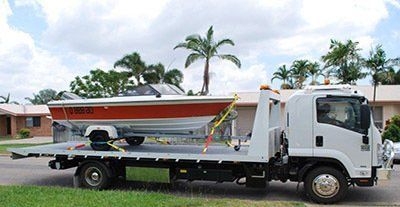 A Tow Truck With A Boat On The Back Of It — Day & Night Towing & Transport In Condon, QLD