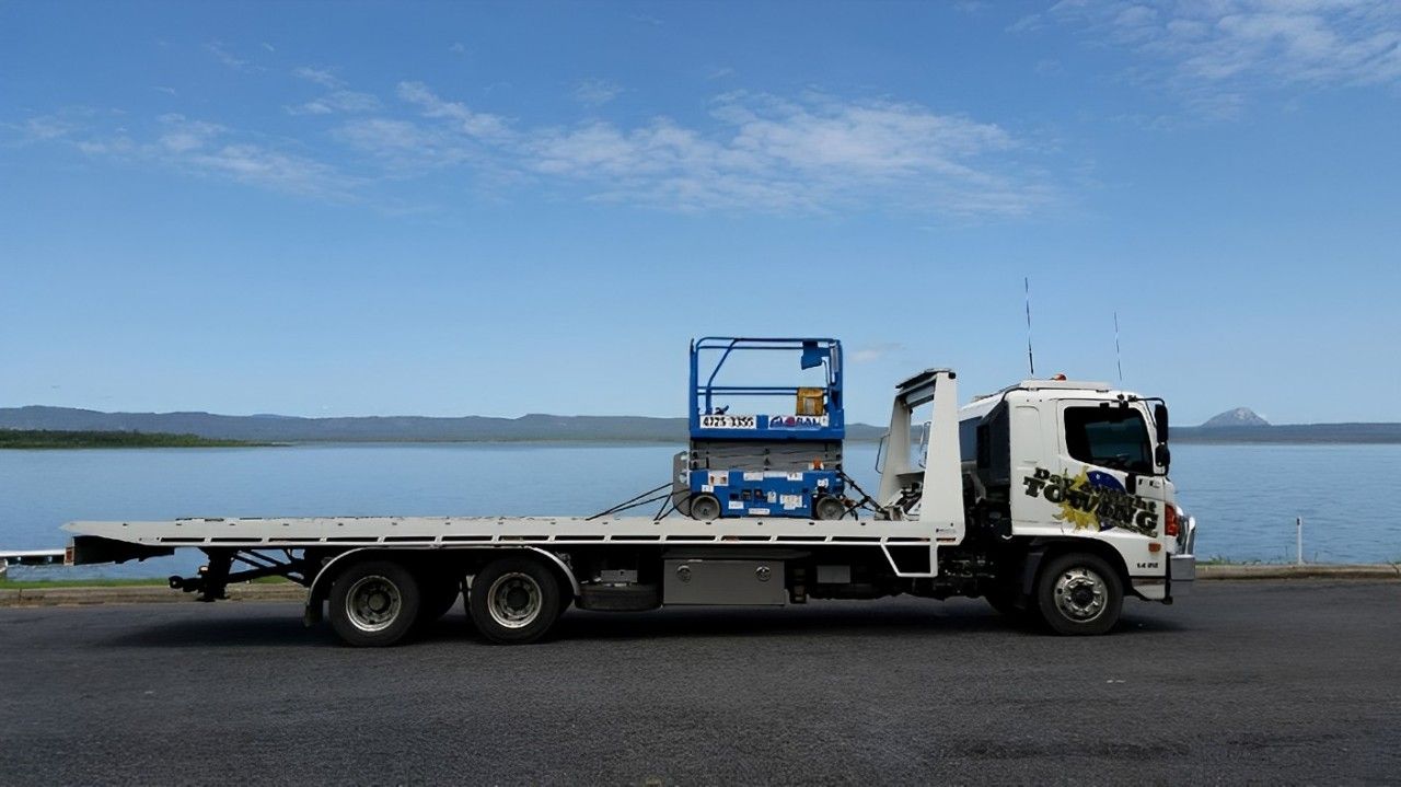 A Flatbed Truck With A Ladder On The Back Is Parked  — Day & Night Towing & Transport In Condon, QLD