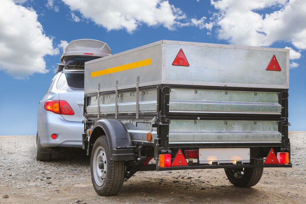 A Car Is Towing A Trailer On A Dirt Road — Day & Night Towing & Transport In Condon, QLD