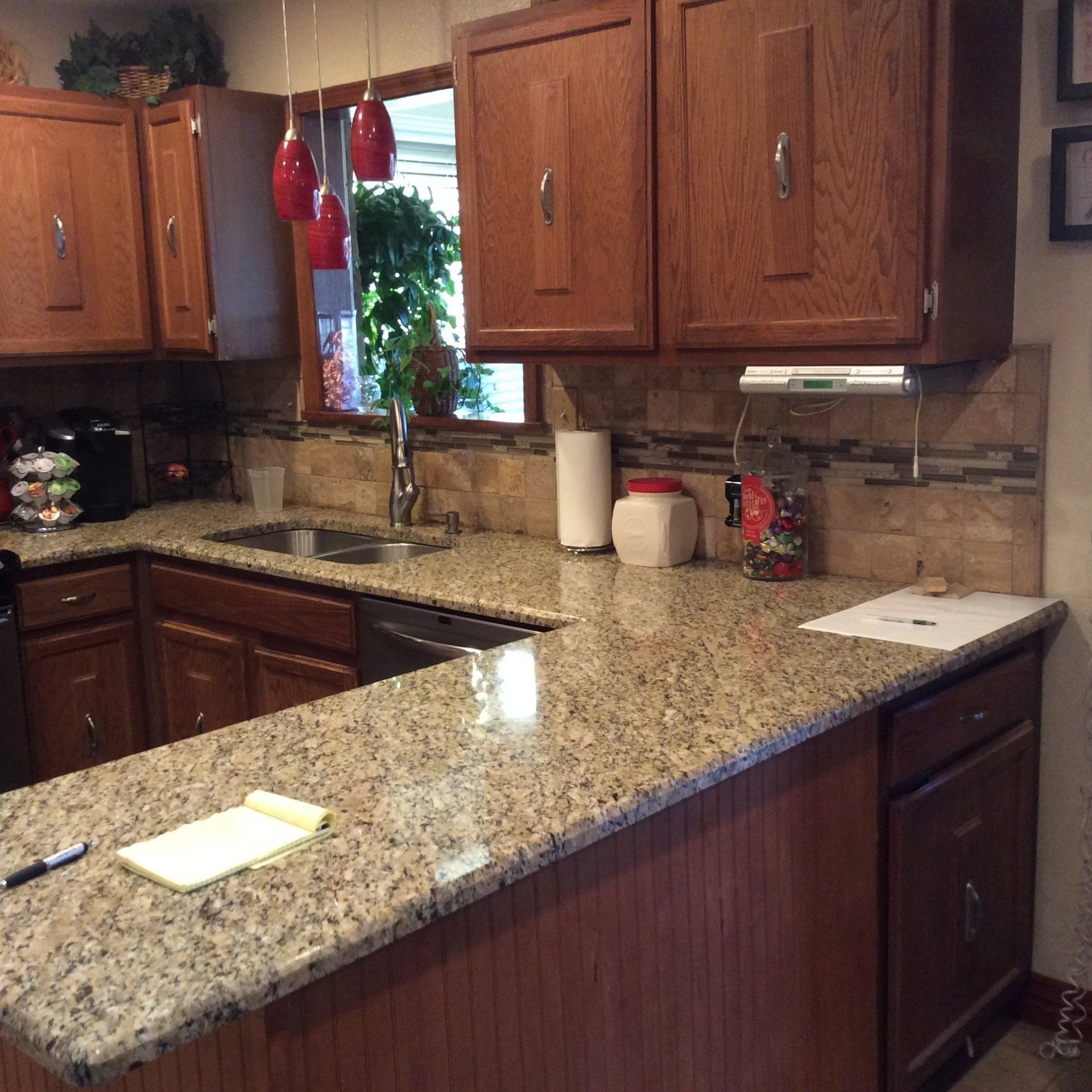 A kitchen with granite counter tops and wooden cabinets