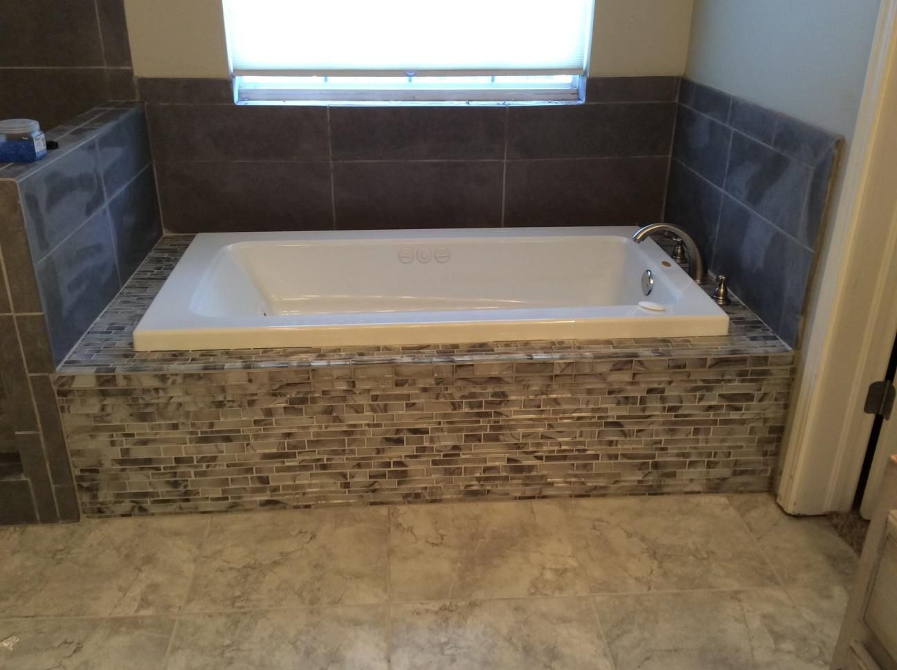 A bathtub is sitting in a bathroom next to a window.