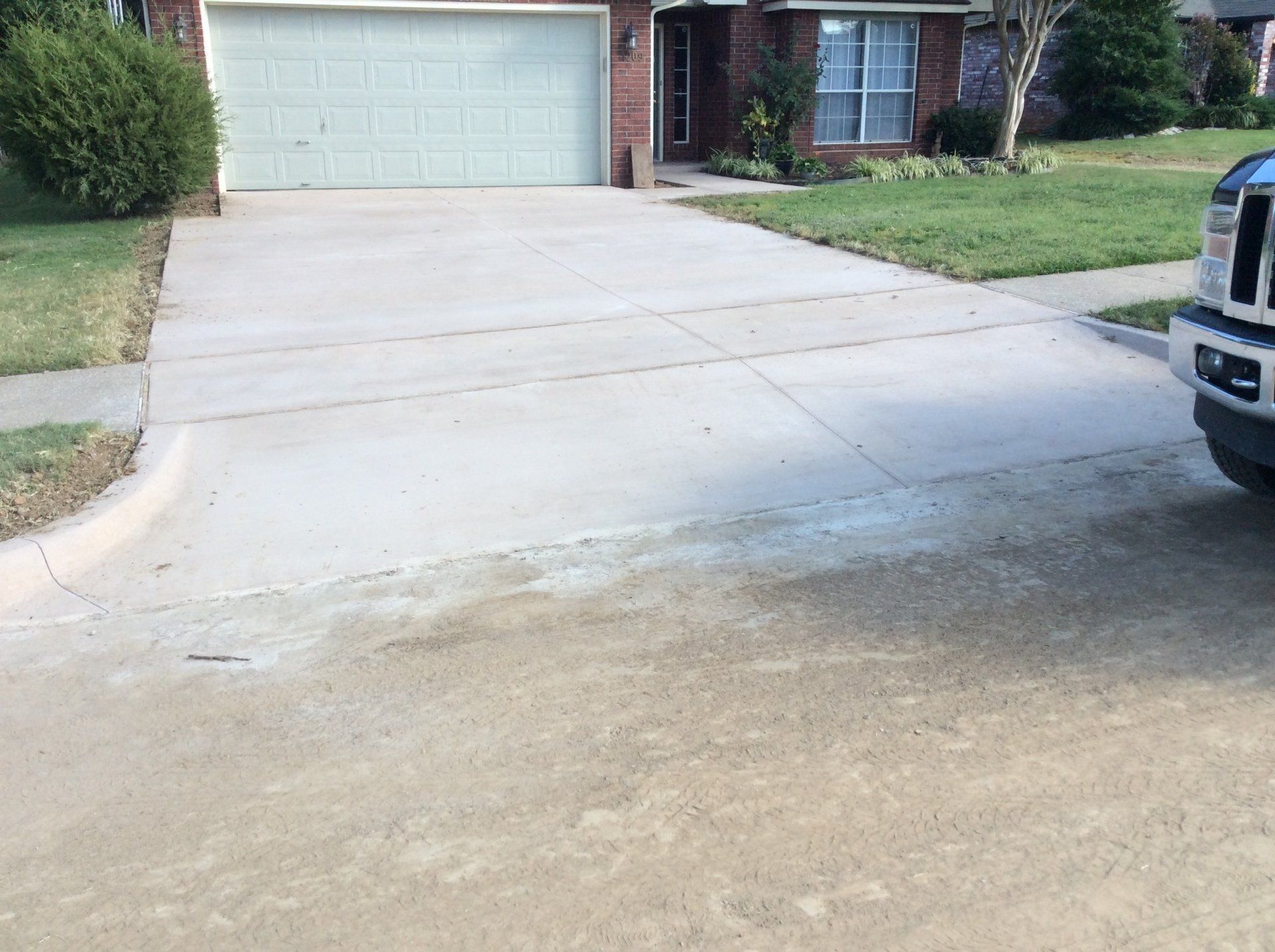 A truck is parked in a driveway in front of a house.
