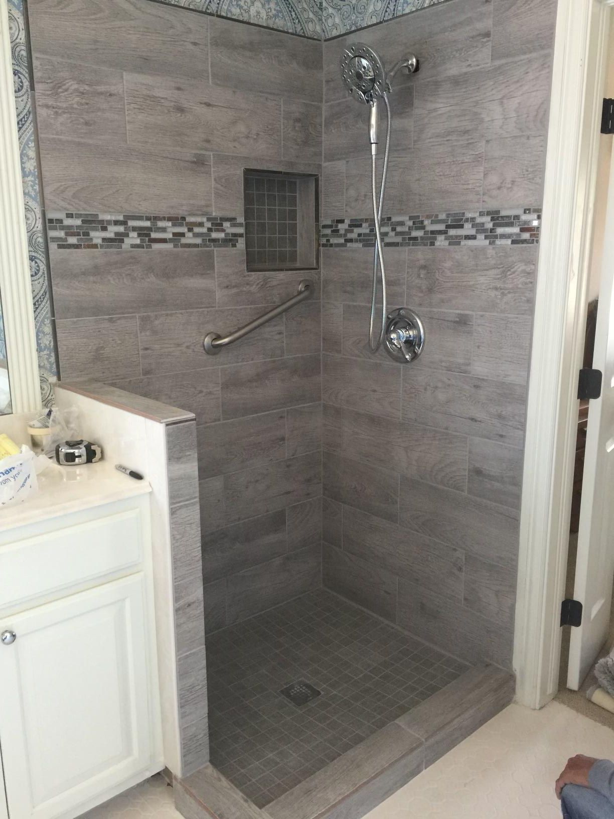 A bathroom with a walk in shower and a sink.