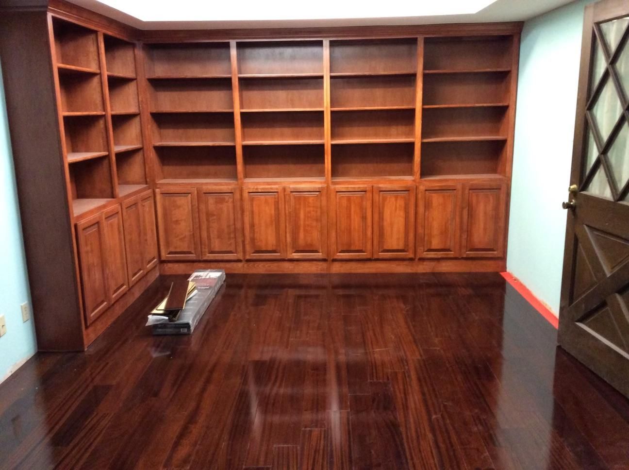 A room with lots of wooden shelves and cabinets