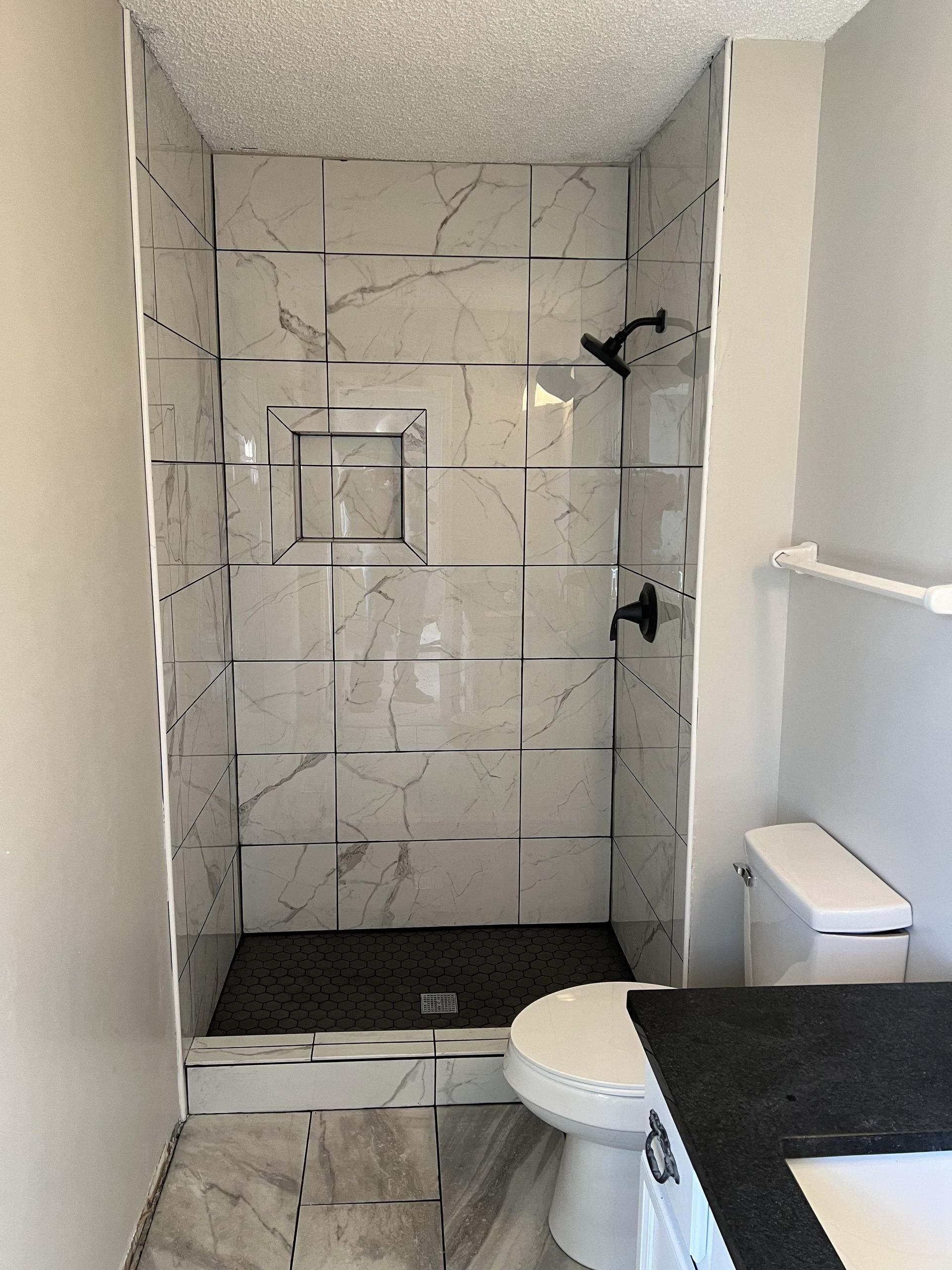 A bathroom with a toilet and a walk in shower