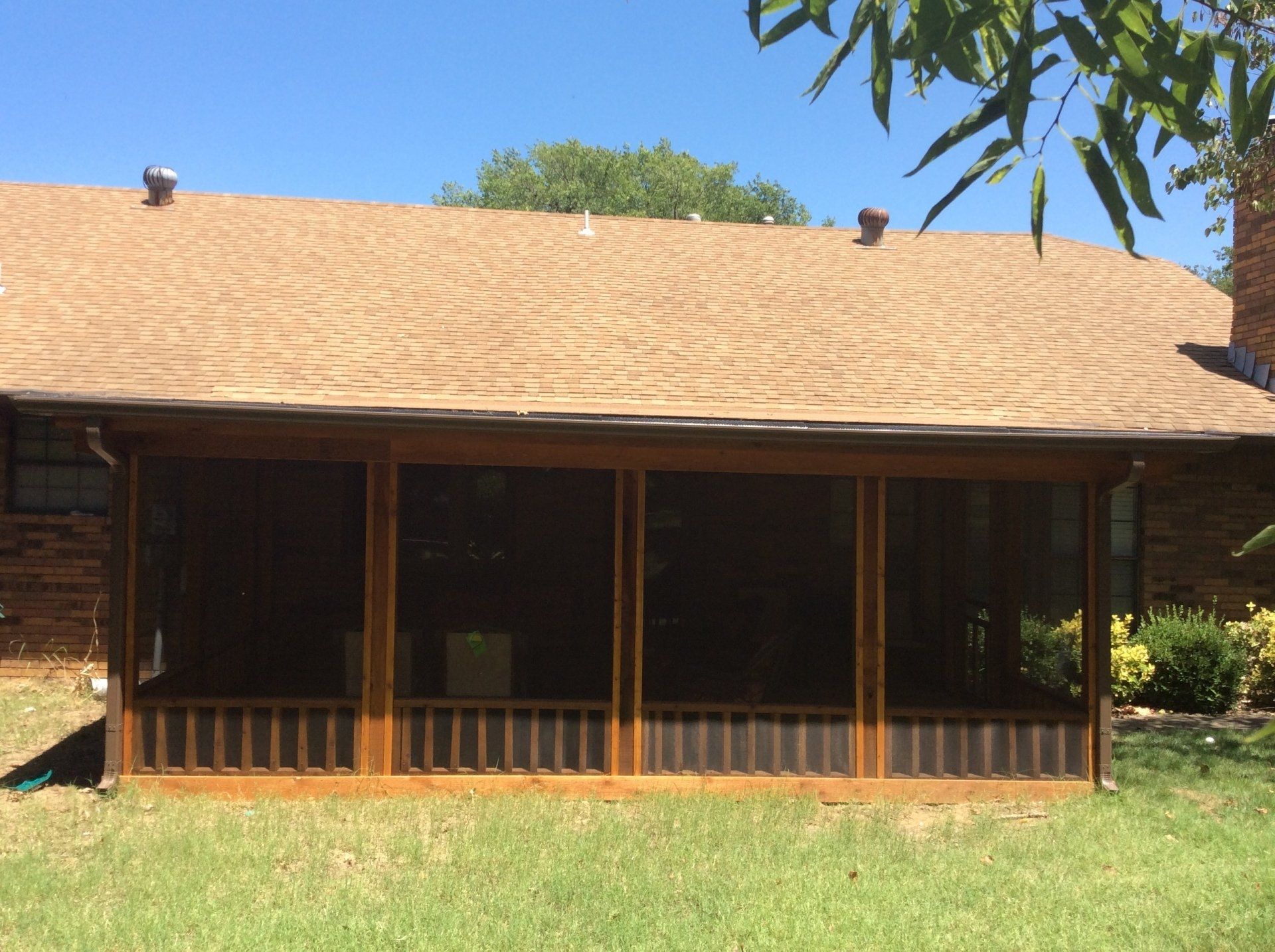 A house with a screened in porch and a roof