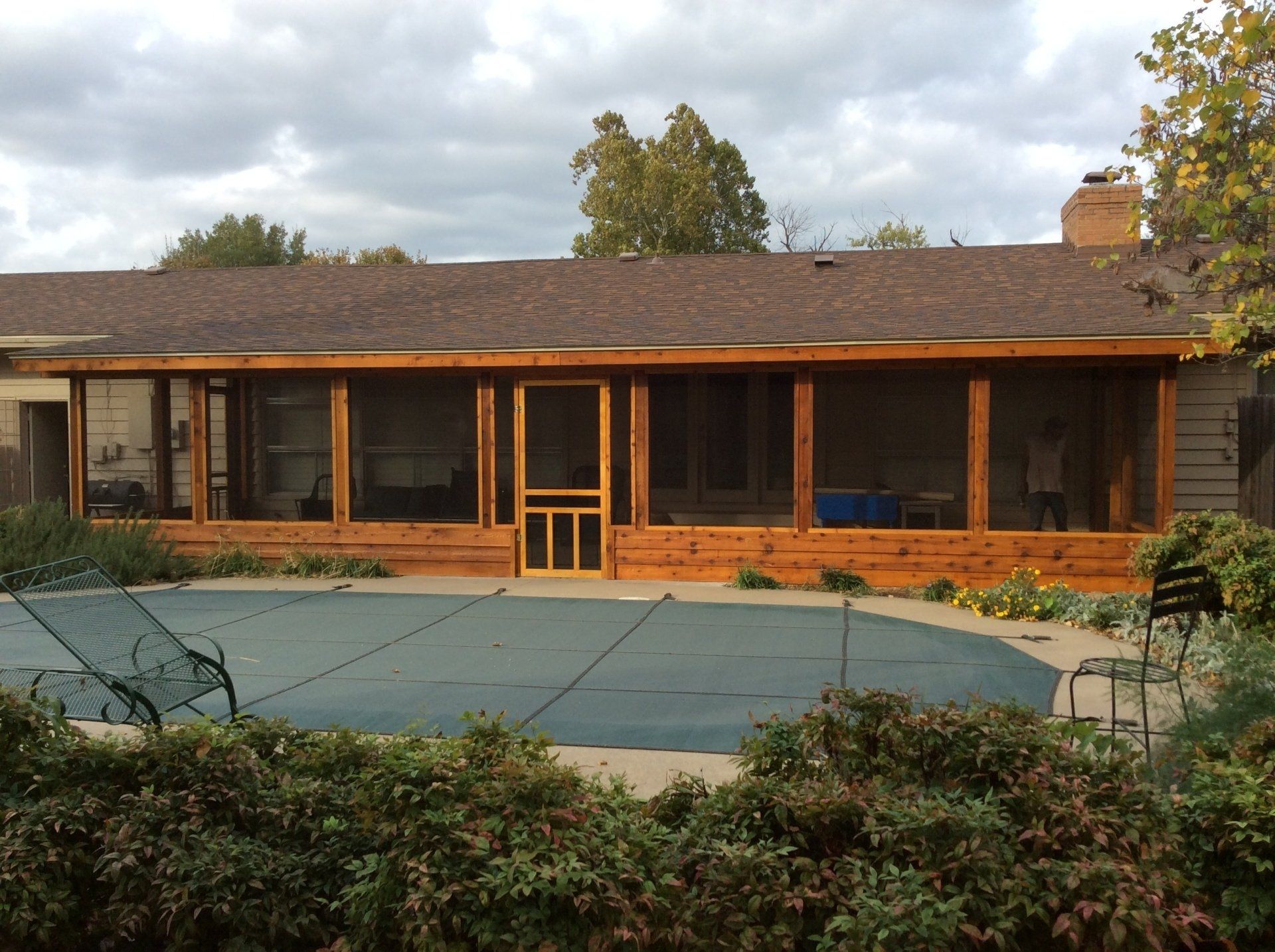 A house with a screened in porch and a swimming pool