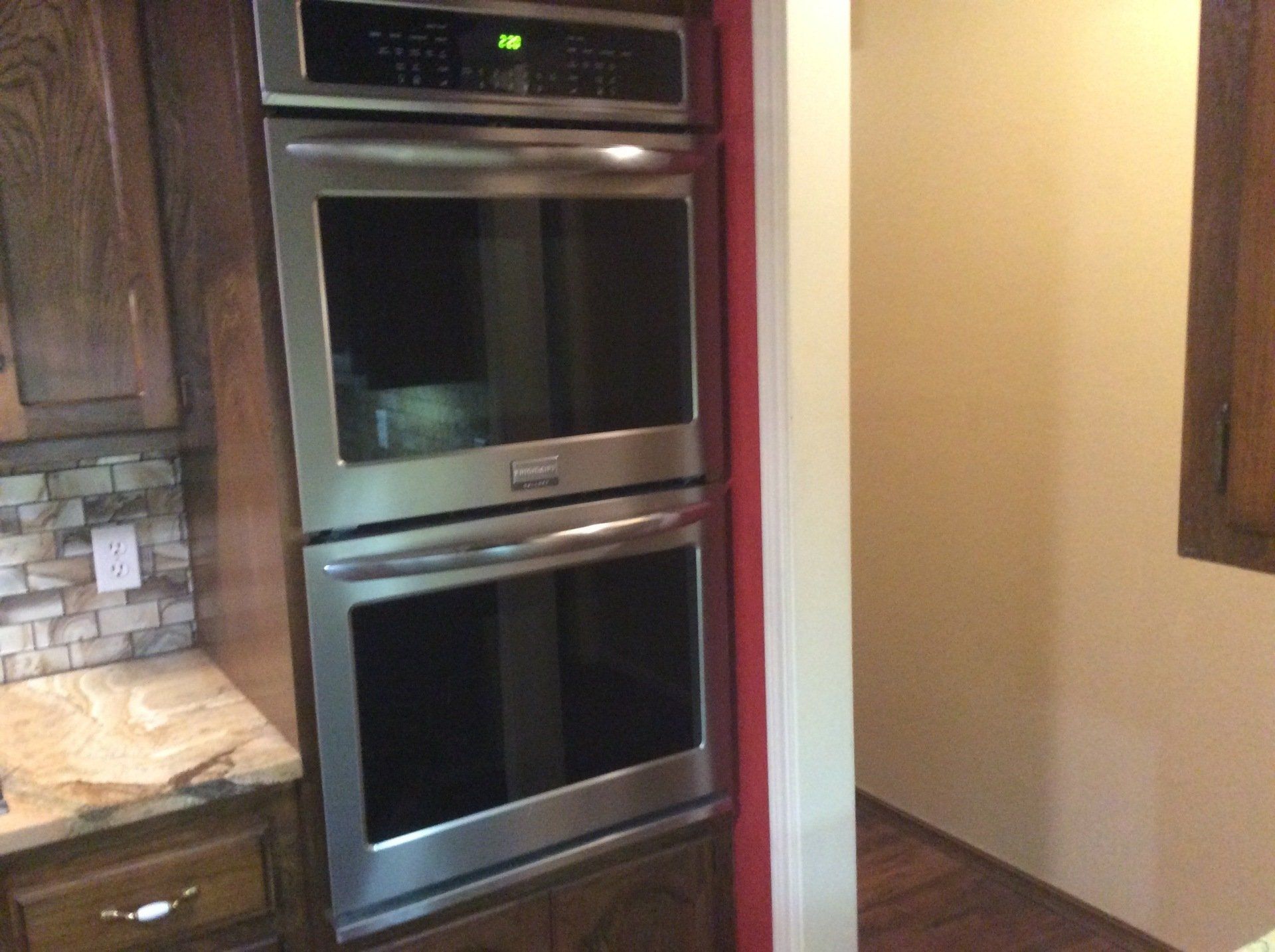 A kitchen with two ovens and a microwave.